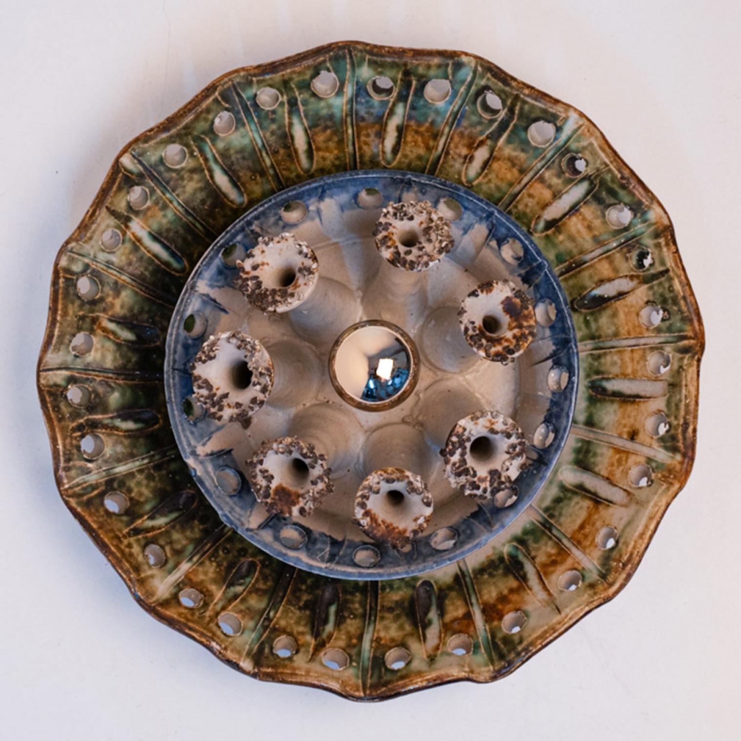 Espectacular aplique circular de cerámica, con bonitos detalles. Fabricado en Dinamarca en la década de 1970.

Limpio, bien cableado y listo para usar.
La luminaria requiere una sola bombilla estándar E14.

Dimensiones:

Diámetro 12,99