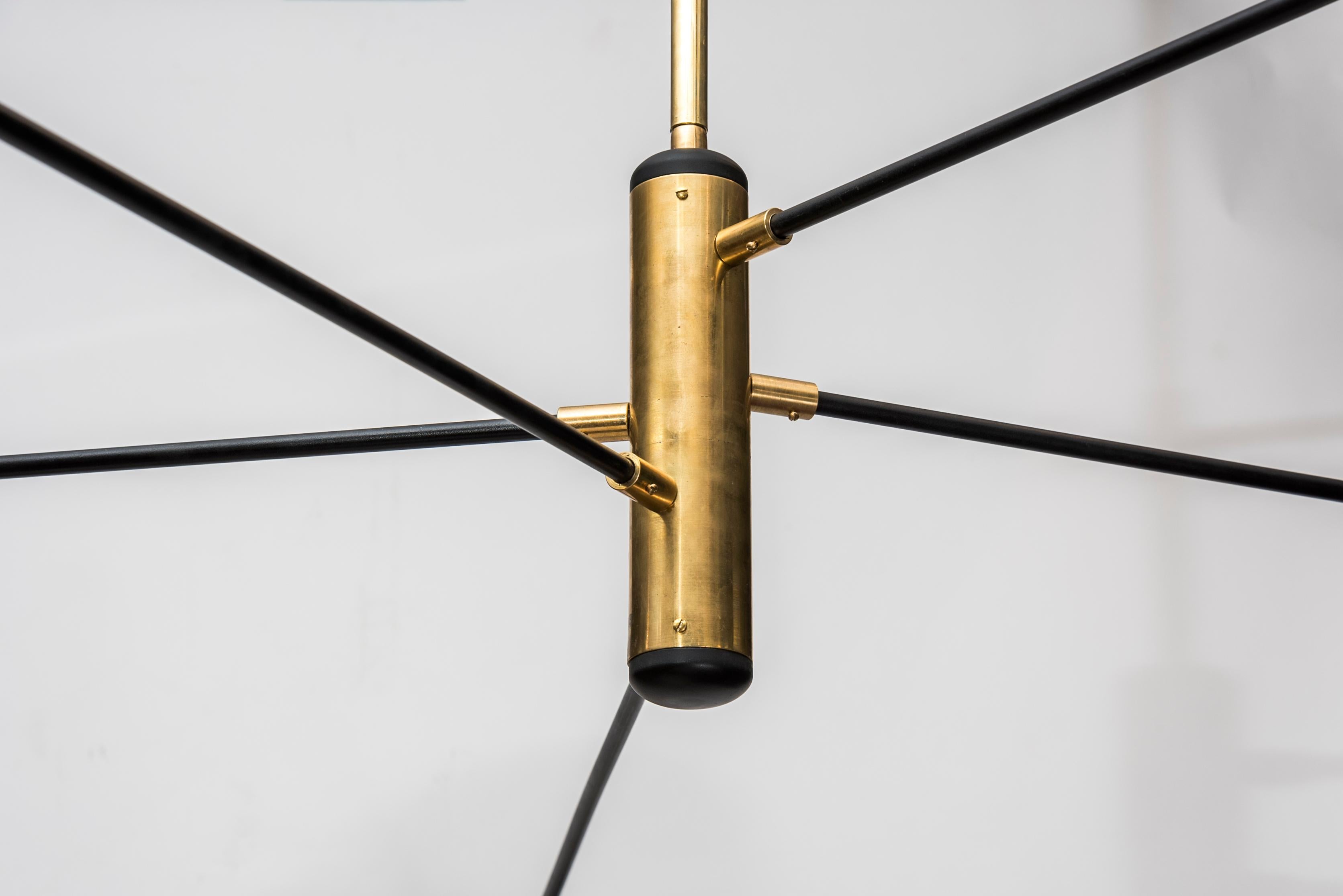This chandelier designed by Studio Glustin is made of brass. It is composed of five arms holding five lightbulbs under black lacquered lampshades.