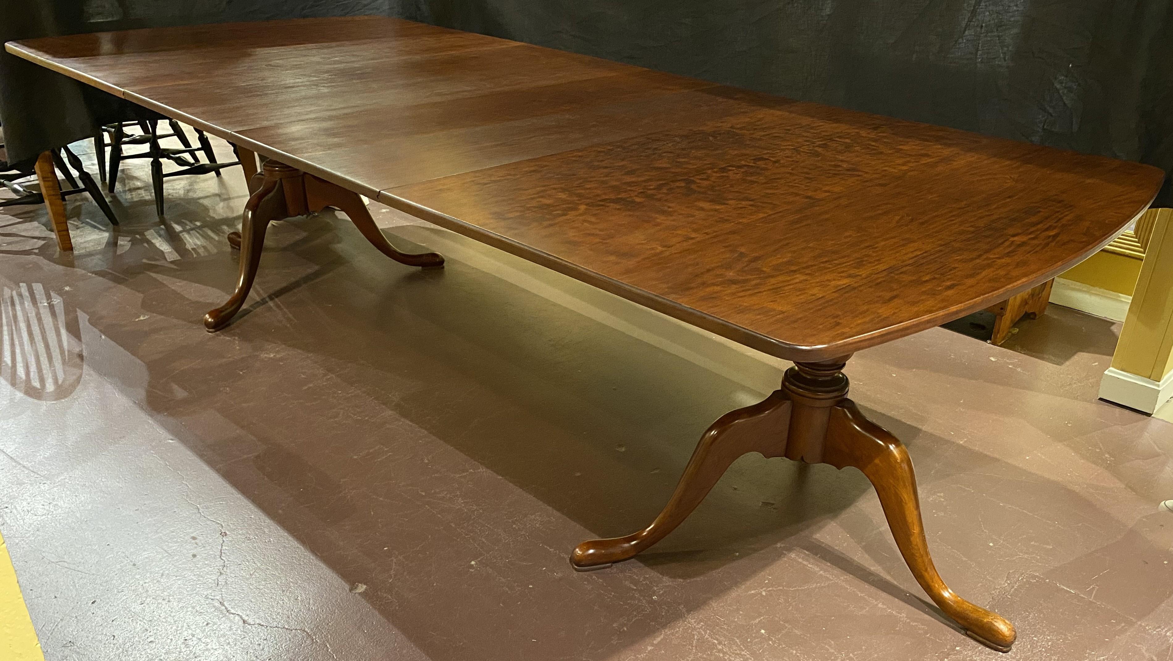 A fine Queen Anne style cherry wood double pedestal dining table, attributed to Eldred Wheeler of Hingham, MA, rectangular form with rounded ends, with two 20 inch tongue and groove finished leaves, expandable supports under the leaves, and tripod