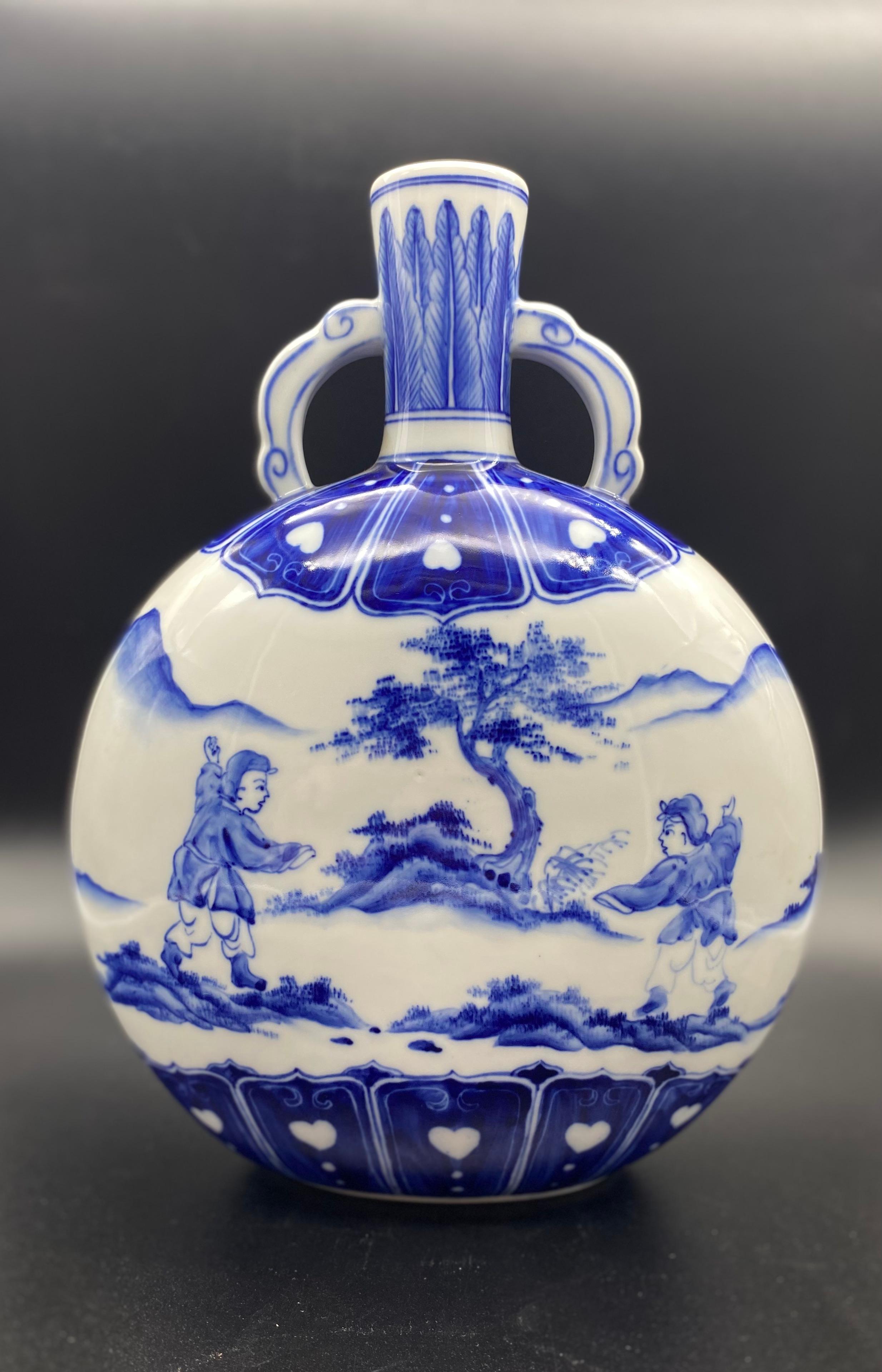 Magnifique vase gourde chinois en porcelaine blanche et bleue.
Porcelaine de bonne qualité pour ce joli objet décoratif.
Deux décorations de chaque côté du vase.
Les décorations représentent deux personnages dans un paysage montagneux avec un arbre