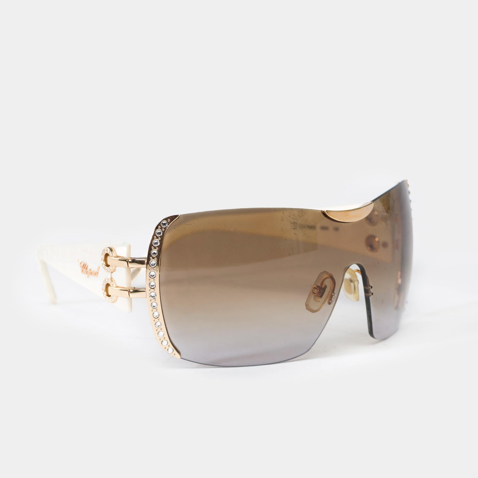 Beautiful​ ​Chopard​ ​sunglasses,​ ​mask​ ​model,​ ​gold​ ​metal​ ​frame​ ​and​ ​temples​ ​covered​ ​in​ ​white​ ​crocodile​ ​print​ ​leather
Gold​ ​metal​ ​trim​ ​and​ ​side​ ​rhinestones
Smoke​ ​lenses

Reference:102241

Condition:​ ​8.5/10
In​