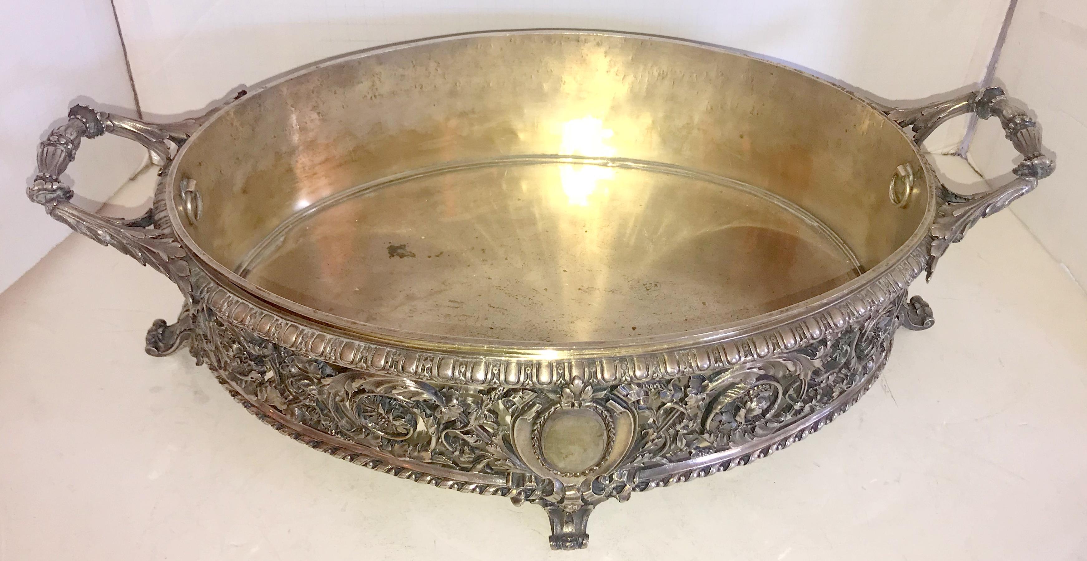 A wonderful French silver plated over bronze centrepiece with insert by Christofle, this beautiful centrepiece is adorned with filigree and pierced design and is cantered with a crest ending on either side with very fine detailed handles and raised