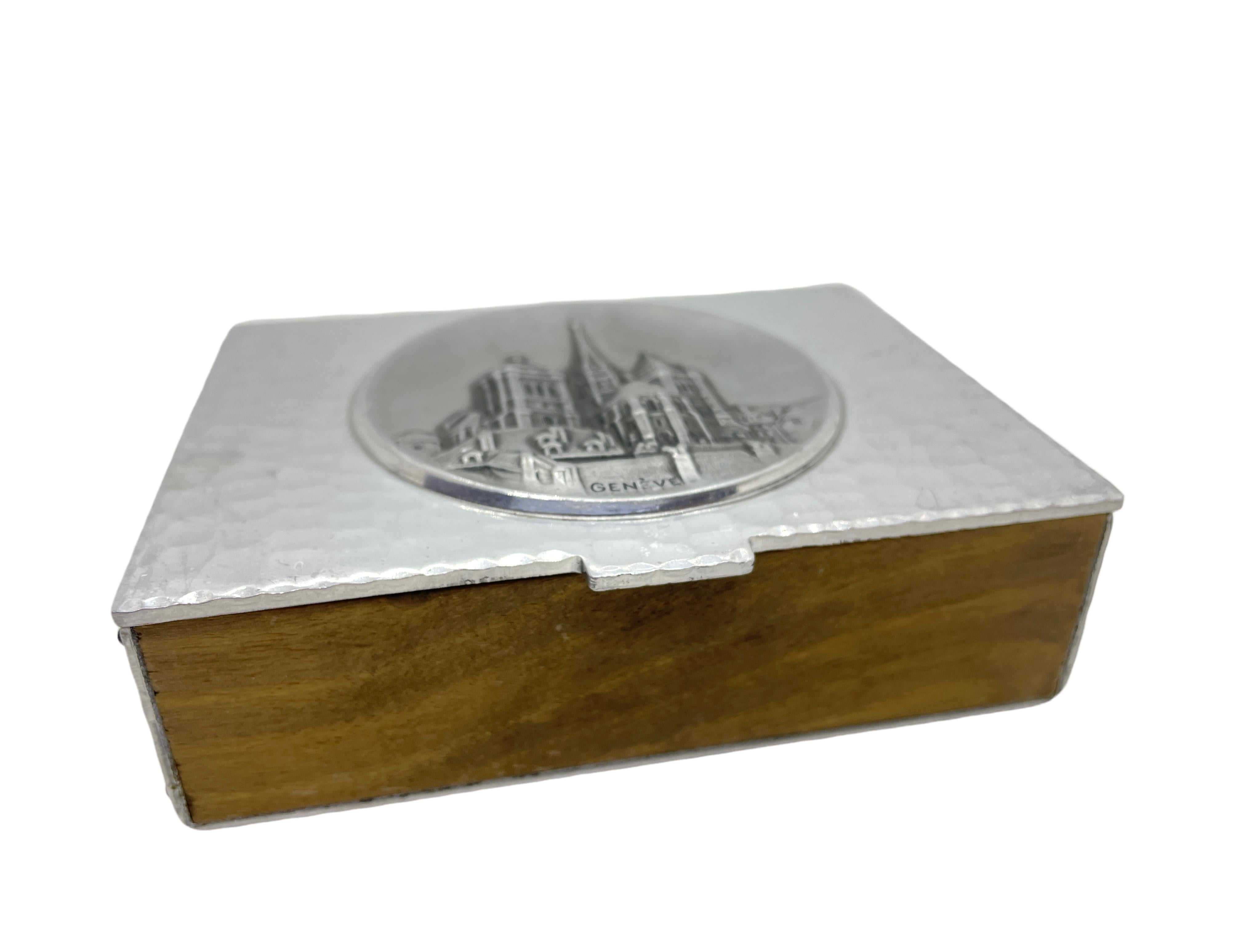 Cigarette box made of cedar wood and hand-hammered metal by SIGG SIGAL Switzerland. It has a beautiful patina with a view scratches at the base or ground. A nice addition in every man cave.