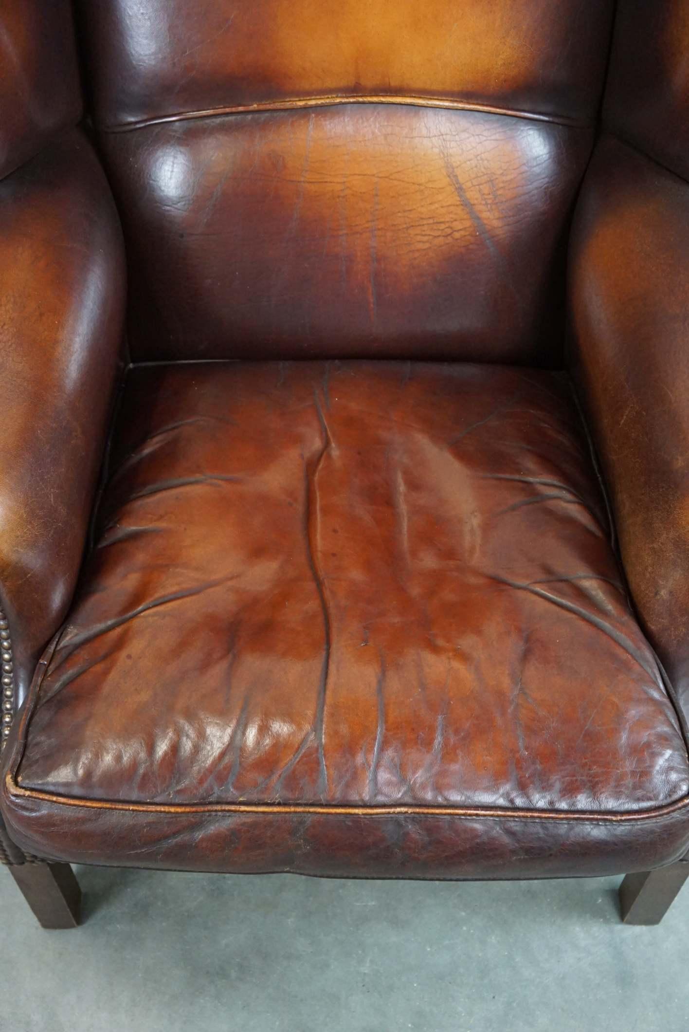 Leather Beautiful classic and stately wingback armchair made of sheep leather with lovel For Sale