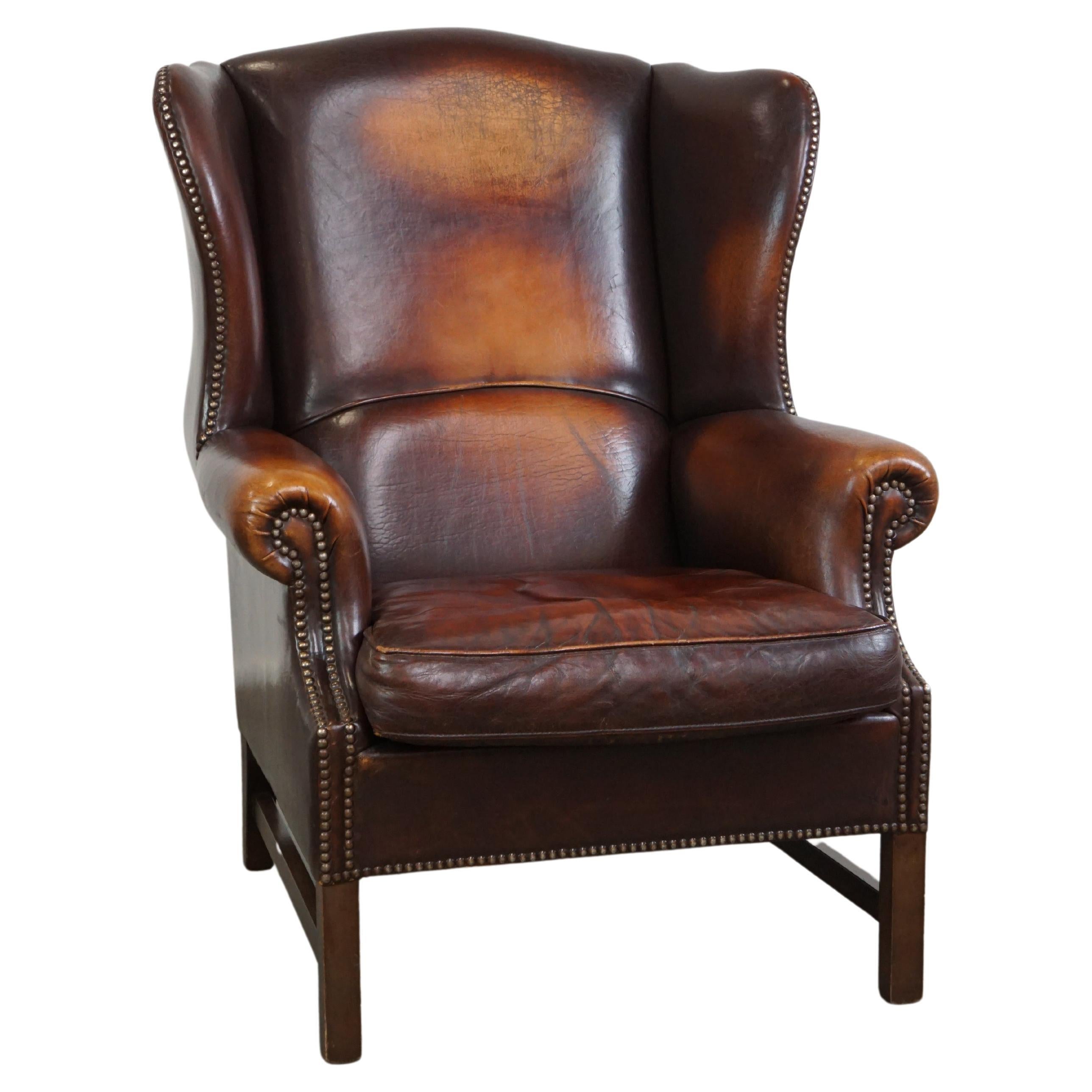 Beautiful classic and stately wingback armchair made of sheep leather with lovel For Sale
