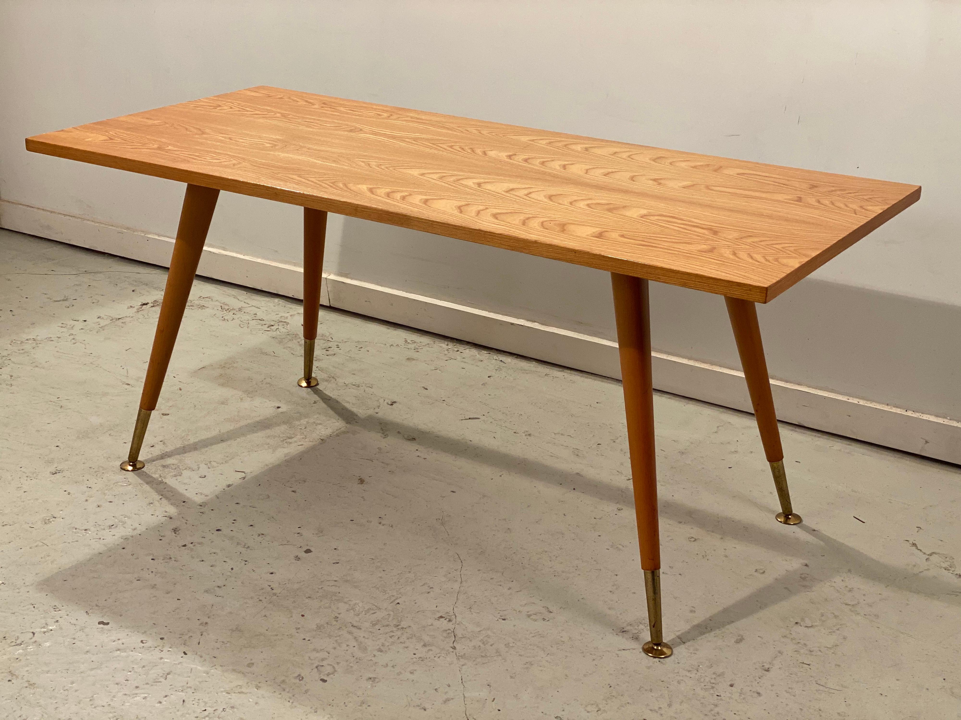 Coffee or side table in beautifully veined very clean high gloss lacquered maple wood. Notice the elegant copper leg tips with floor stabilizers. Marked Ilse Möbel” underneath the tabletop. In very good vintage condition.