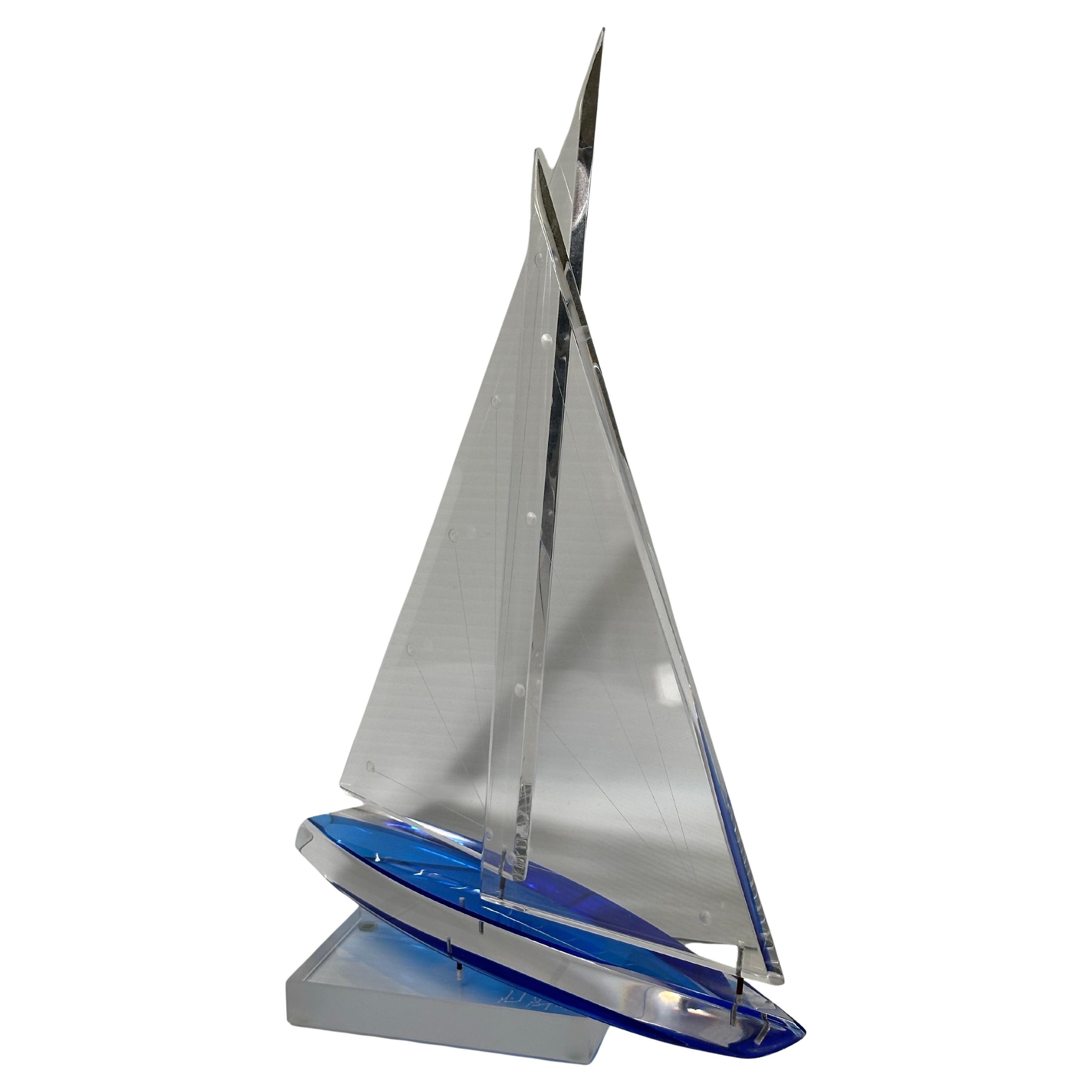 Schöne klare und blaue Lucite Segelboot-Skulptur von Michael George, 1996 unterzeichnet. Diese fantastische America's-Cup-Yacht hat einen festen Rumpf und zwei bewegliche Segel mit einem geschnitzten linearen Punktmuster auf beiden Segeln. Das Stück
