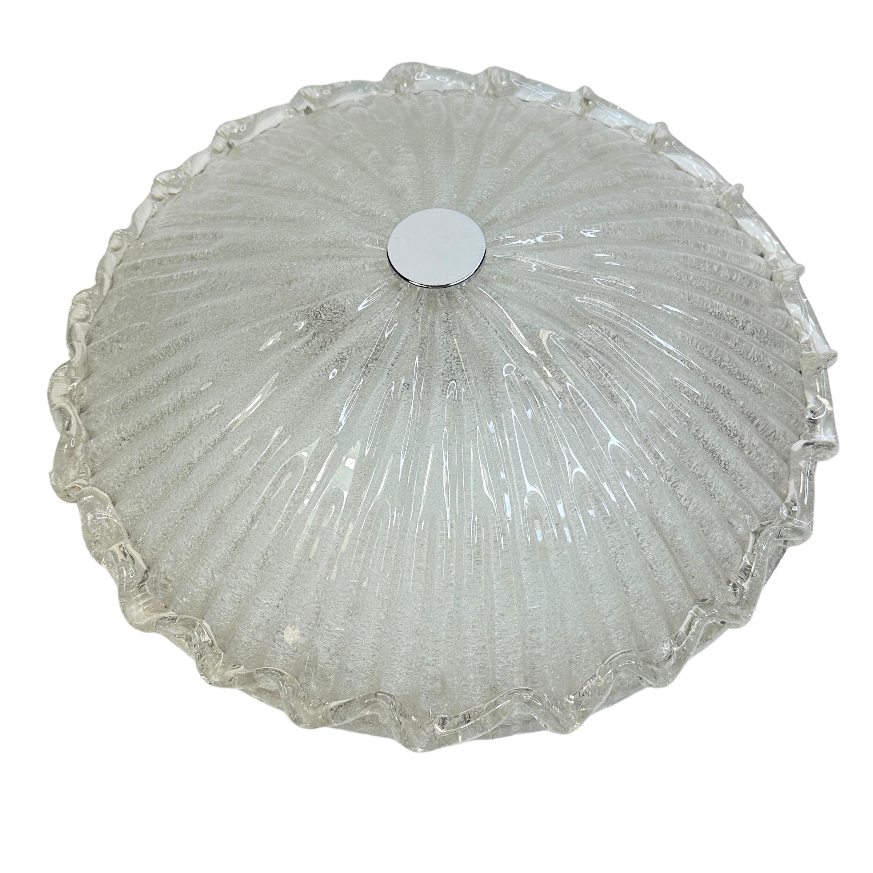 This exquisite flush mount chandelier attributed to the legendary atelier of Venini in Italy, circa 1970s. It features a subtly concave and channeled hand blown thick and heavy Murano glass shade. The glass shade is made of clear glass in ice