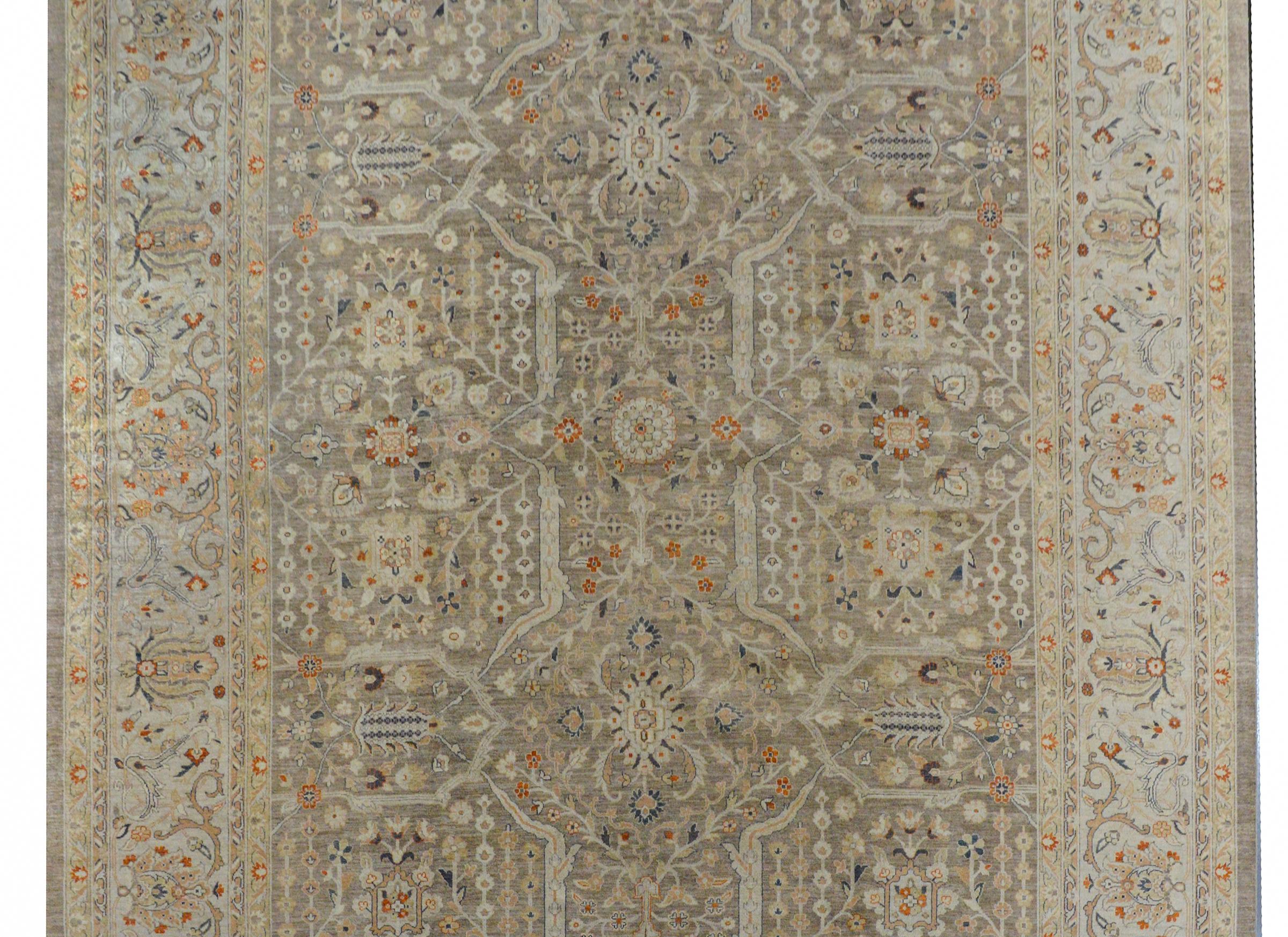 A beautiful contemporary Indian Peshawar rug with an all-over pattern of myriad flowers, vines, and leaves woven in orange, indigo, gold, and cream colored wool on a gray background. The border is woven in similar colors with a wide floral and vine