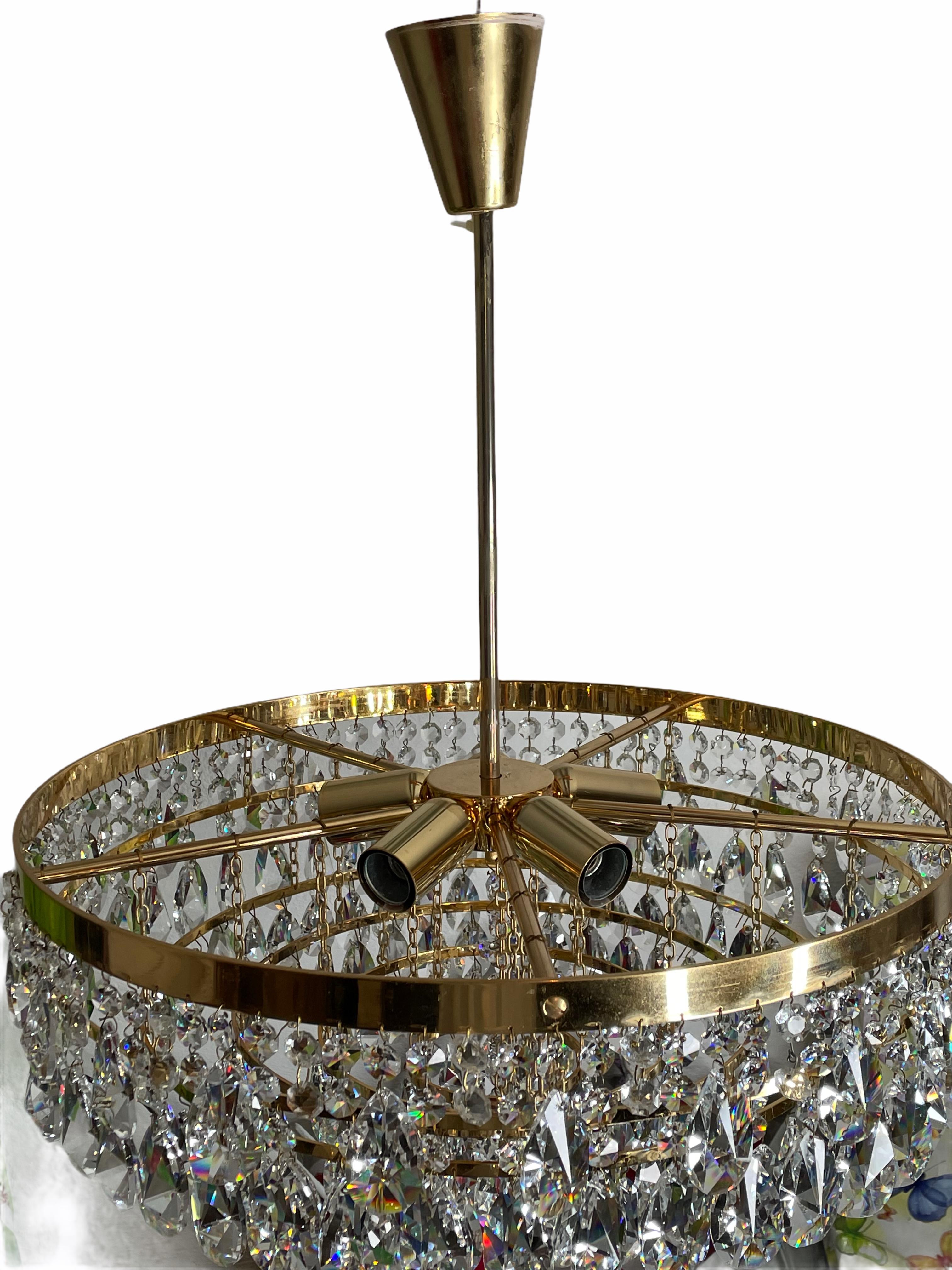 A beautiful 6-tiered brass and crystal glass chandelier made by Palwa Leuchten, Germany, 1960s. The chandelier requires six European E14 candelabra bulbs, each up to 40 watts. It is made of cut crystals and a gold-plated brass frame.
This will look