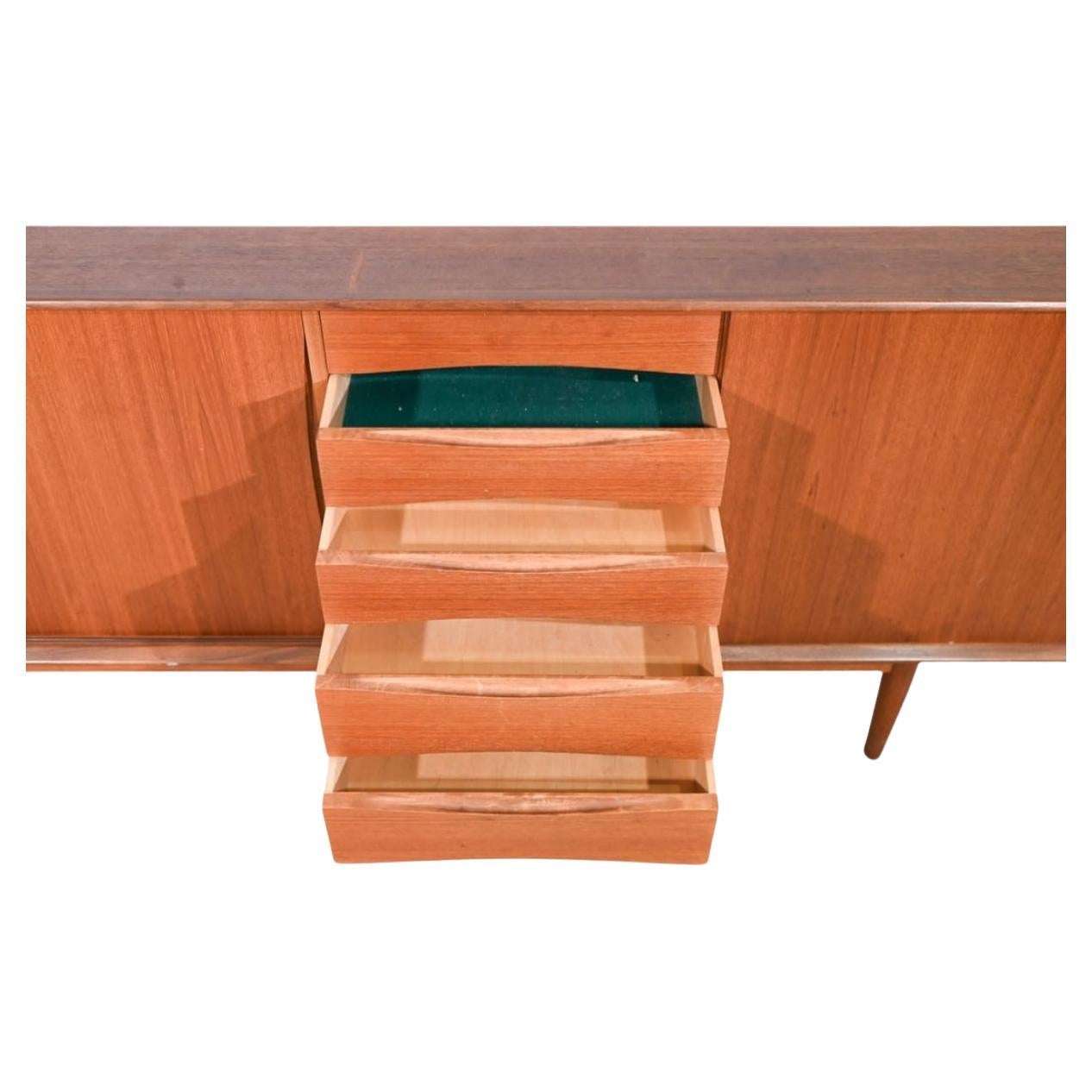 Schöne moderne skandinavische Teakholz-Credenza von Fredrik Kayser. Erstaunliche Konstruktion mit 4 Schubladen aus zentriert dann mit 3 Schiebetüren mit verstellbaren Regalen hinter ihnen. Er steht auf einem massiven Teakholzrahmen mit konisch