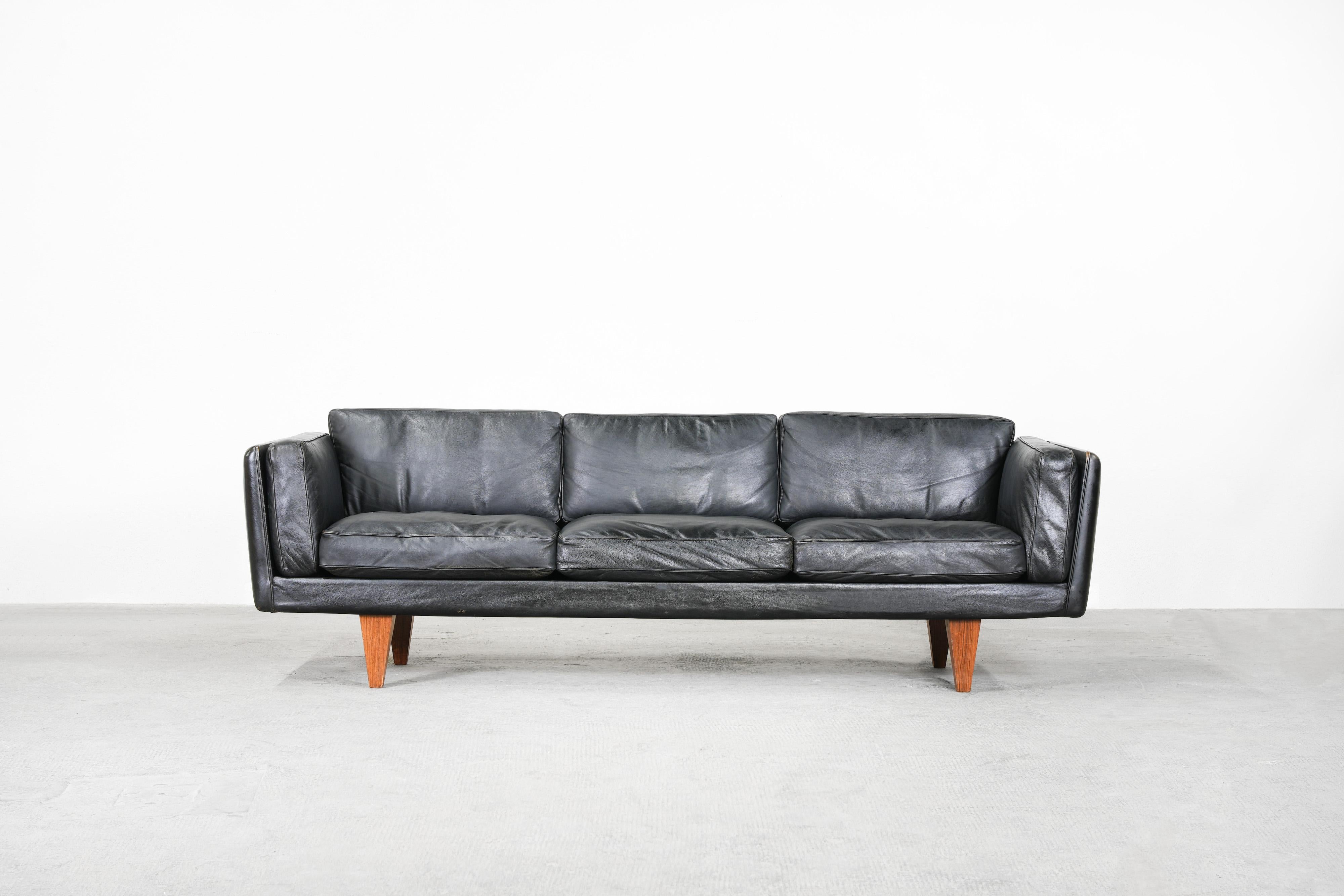 Beautiful Danish sofa designed by Illum Wikkelsø and manufactured by Holger Christiansen in the 1960ies.
The sofa comes in black patinated leather and is in great original condition with just a few traces of usage. The down feathers inside the