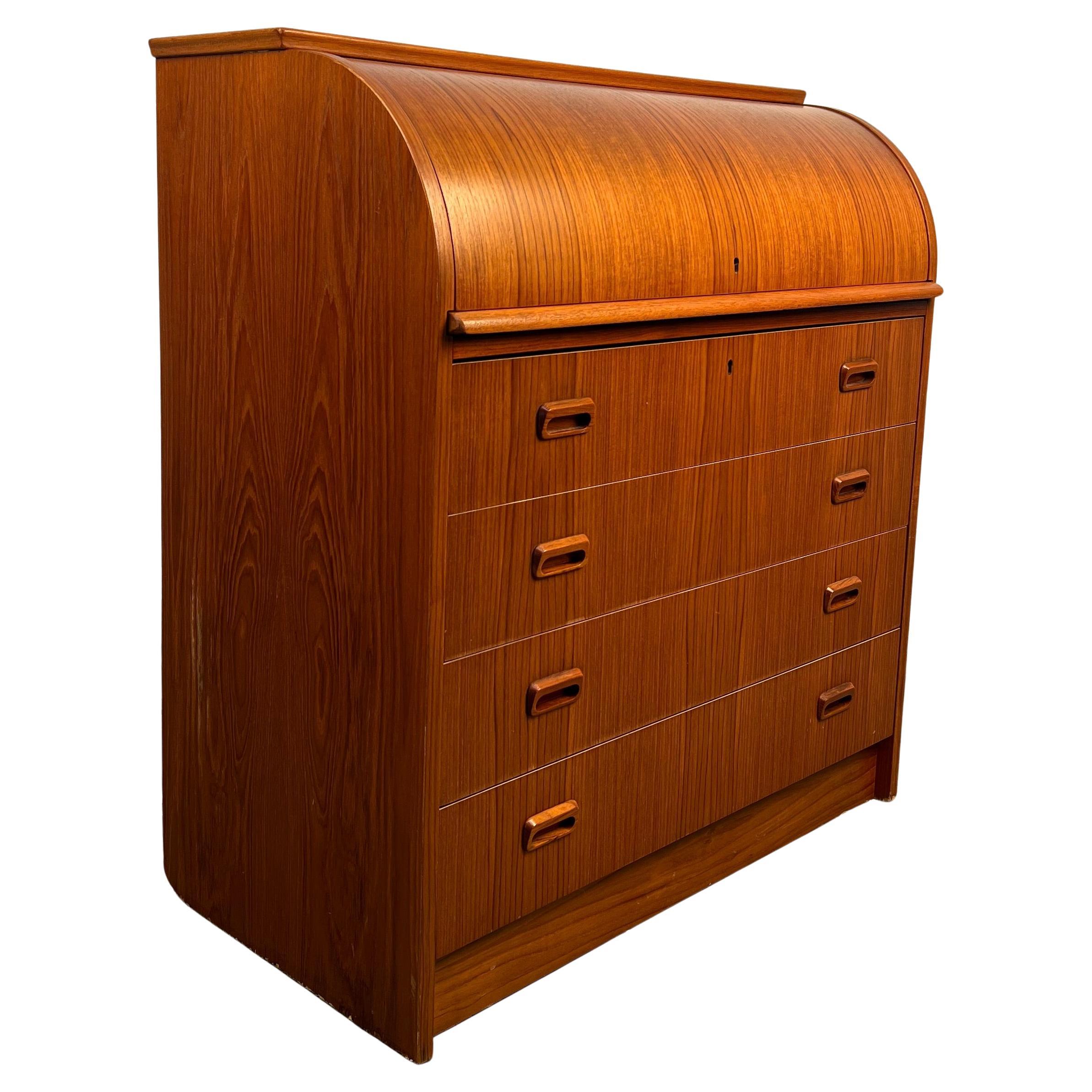 Elegante scrivania danese realizzata in teak, caratterizzata da un design con piano a rotelle e da una silhouette elegante e slanciata. Il pezzo offre un ampio spazio di archiviazione con cassetti e scomparti, combinando funzionalità e stile in una