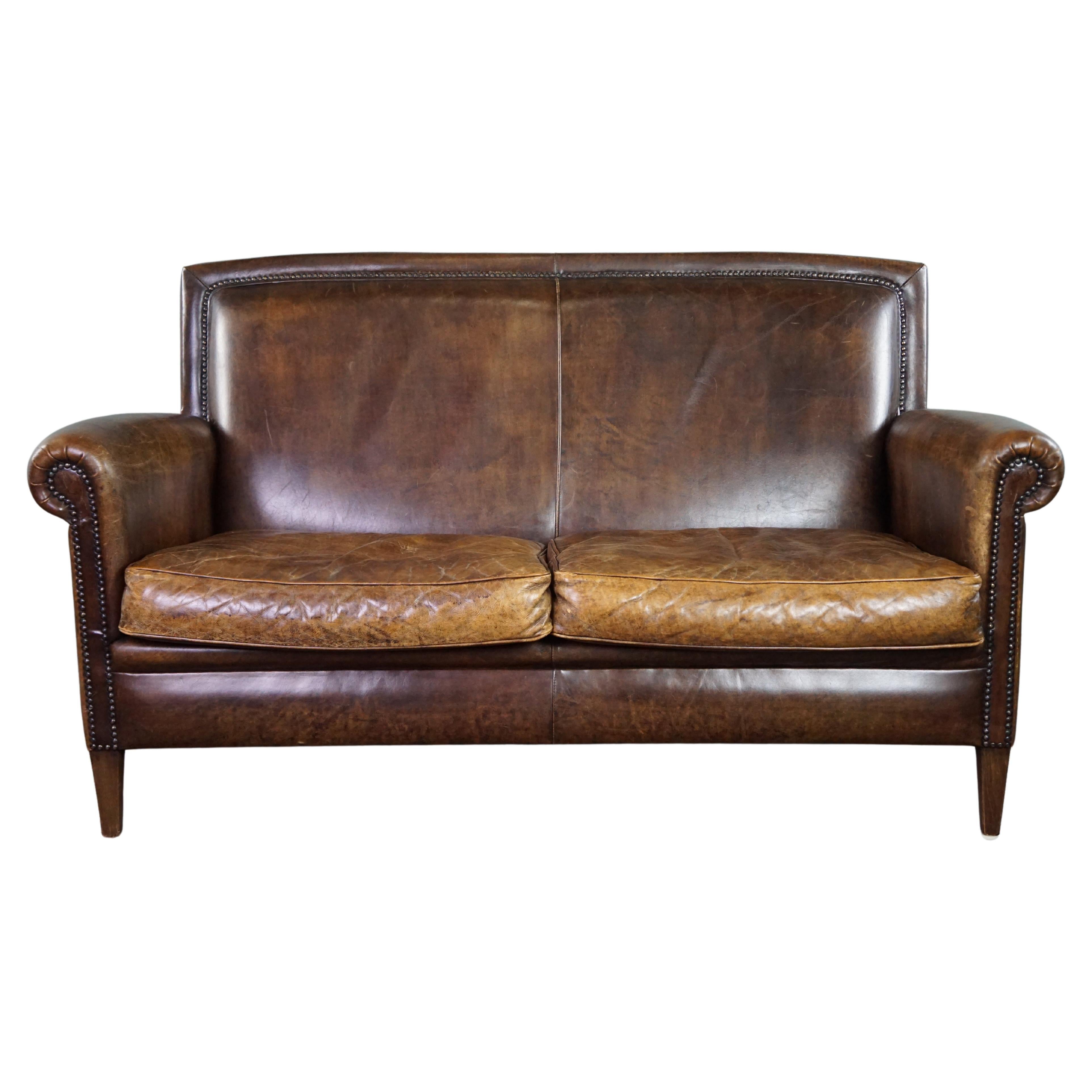 Beautiful dark cognac-colored cowhide 2-seater sofa in classic English style For Sale