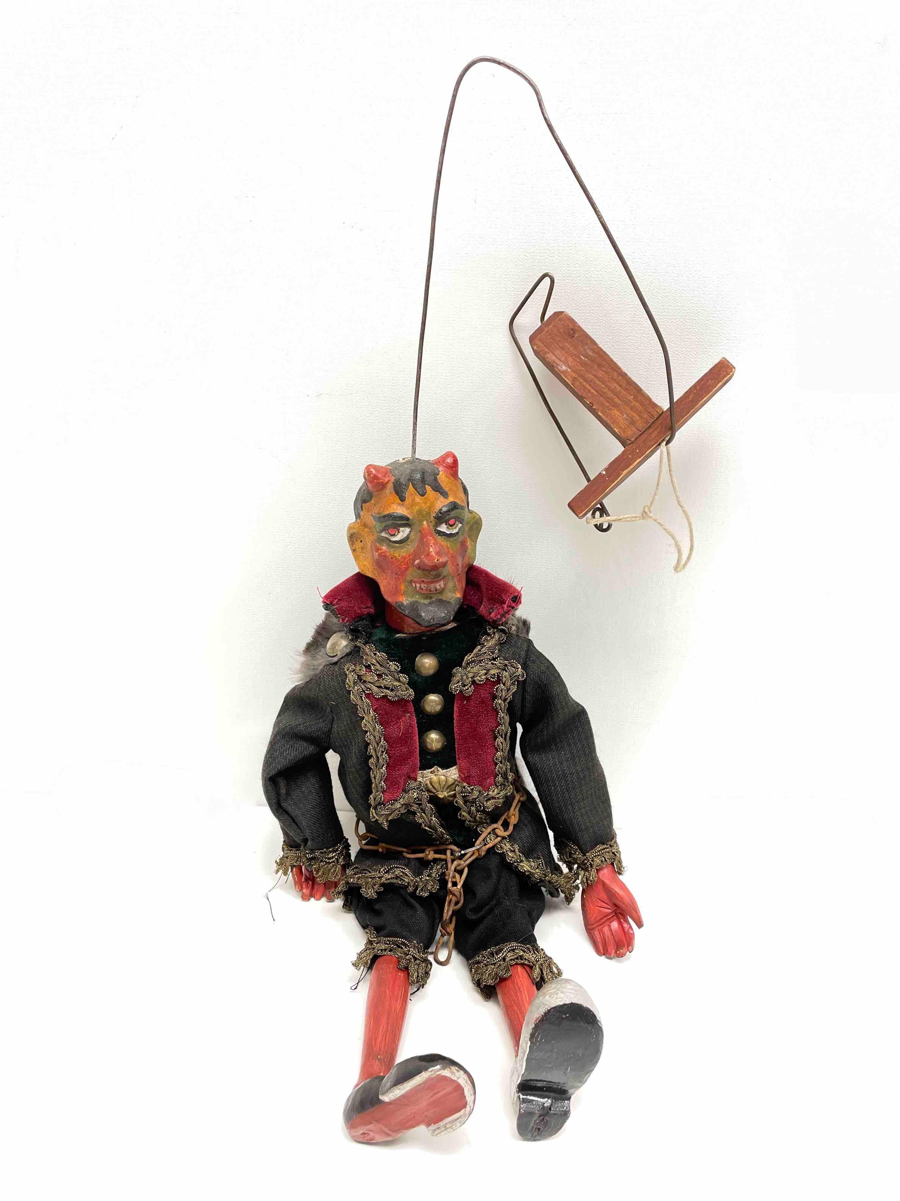 This is a wonderful depiction of Krampus or the devil puppet. The item is approximately 14.5 inches tall and has a skeleton, arms and legs made of wood. Height was measured from foot to the end of the horns. The head is made of wood and composition,