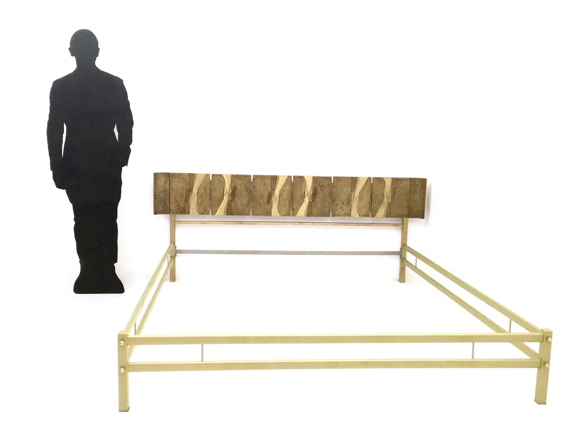 Beautiful sculptural form double bed in a classical style by Luciano Frigerio, circa 1960s.
The very simple structure brings attention to the stunning headboard, which features eight cast bronze panels.
It features brass, metal and varnished metal