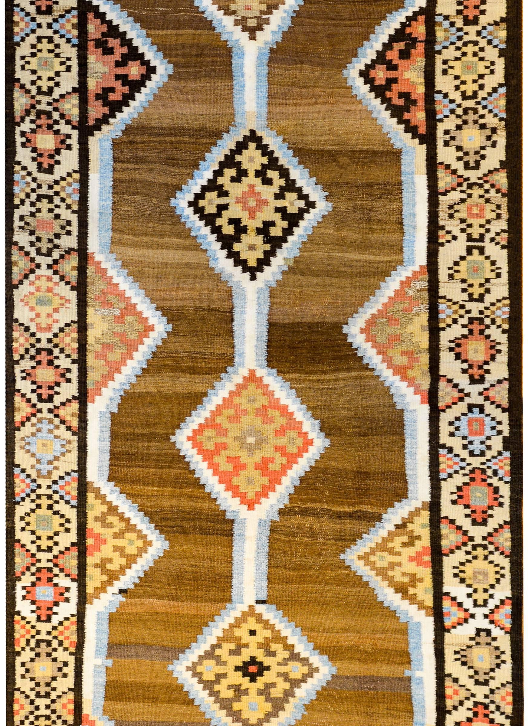 An early 20th century antique Persian Shahseven runner with four geometric diamond medallions on a variegated natural brown, un-dyed, background, surrounded by wonderful complementary multicolored floral and geometric borders.