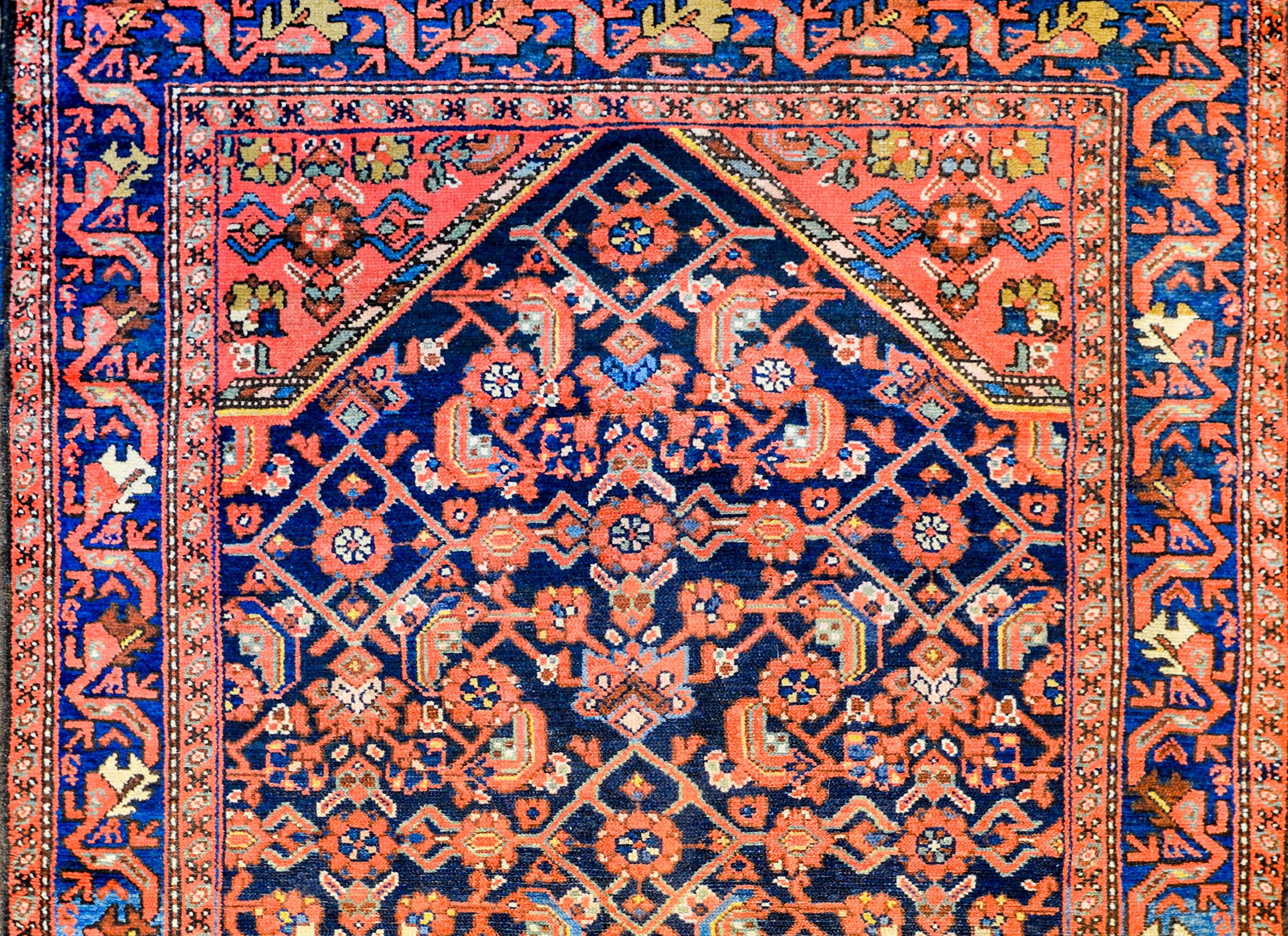 A beautiful early 20th century Persian Hamadan rug with beautiful large diamond medallion with an all-over multi-colored trellis pattern woven in crimson, salmon, light and dark indigo, white, and gold vegetable dyed wool. The border is wonderful