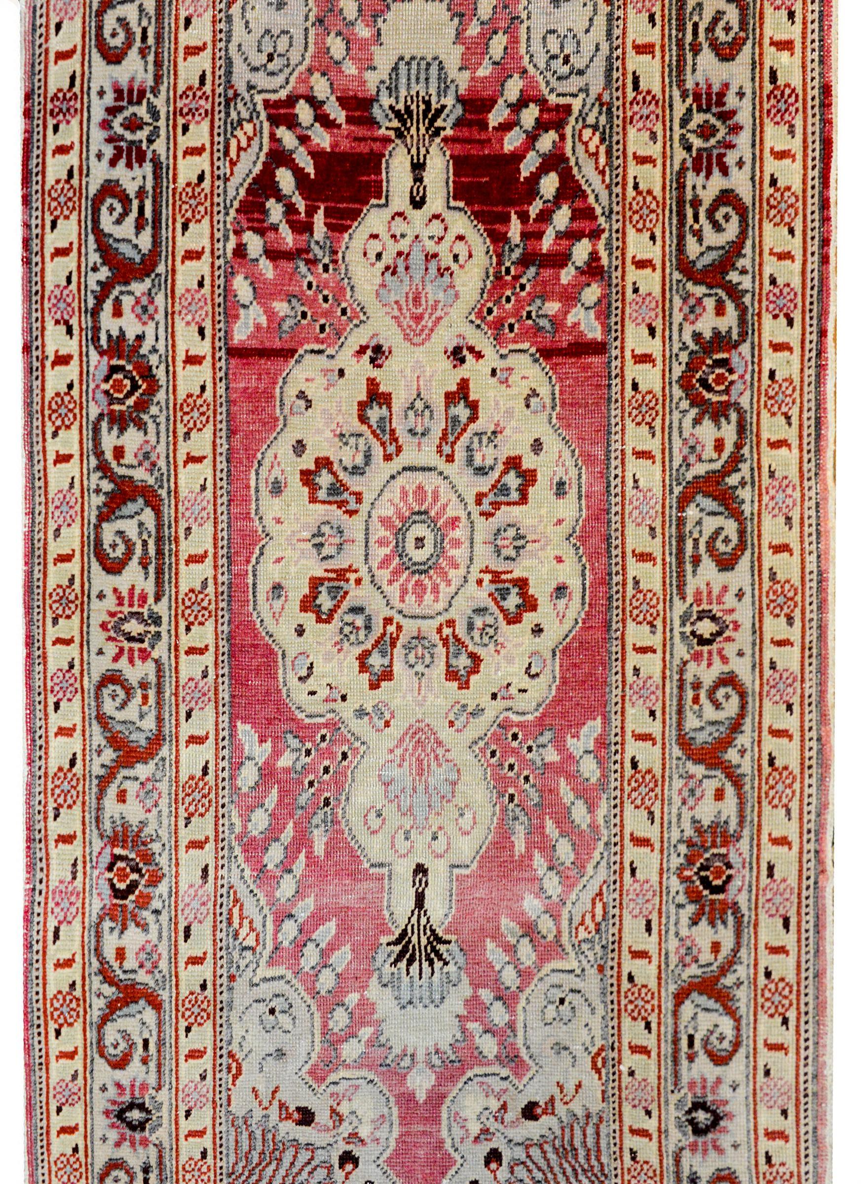 A beautiful early 20th century Persists Tabriz rug with a large central diamond medallion on a bold abrash cranberry background surrounded by a complex border containing a floral and scrolling vine pattern flanked by a pair of petite floral
