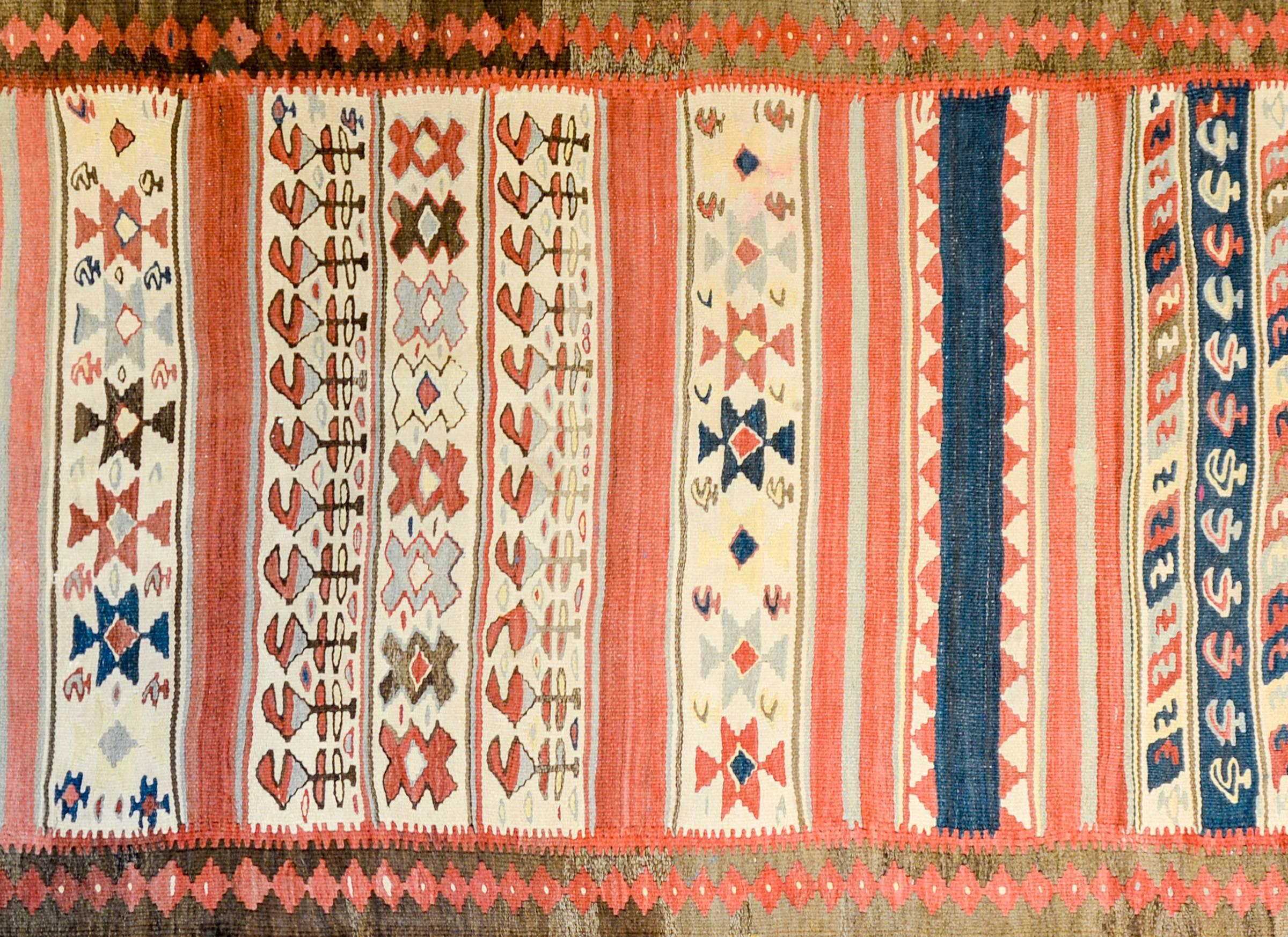 Ein schöner persischer Zarand-Kilim-Läufer aus dem frühen 20. Jahrhundert mit einem fantastischen Muster aus abwechselnd bunten Streifen und Streifen mit stilisierten Blumen, gewebt aus karmesinroter, indigoblauer, grüner, brauner und naturfarbener