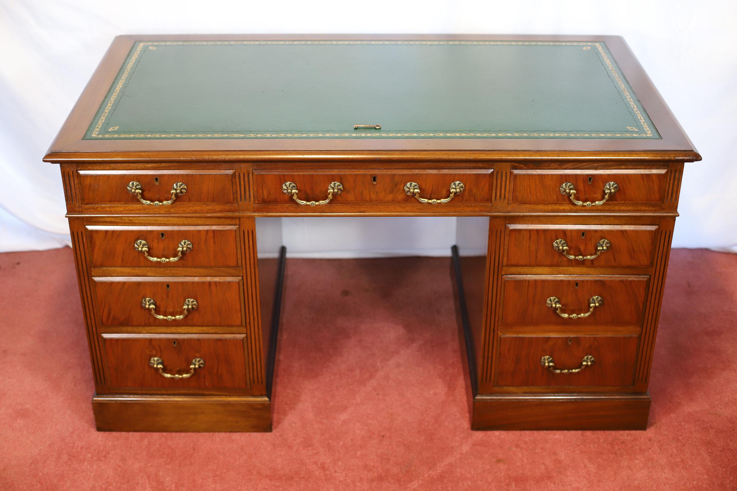 Nos complace ofrecer este precioso escritorio de doble pedestal de principios del siglo XX. Con borde moldurado, parte superior con un panel de cuero verde labrado, sobre tres cajones con friso, flanqueados por tres cajones a la izquierda y tres
