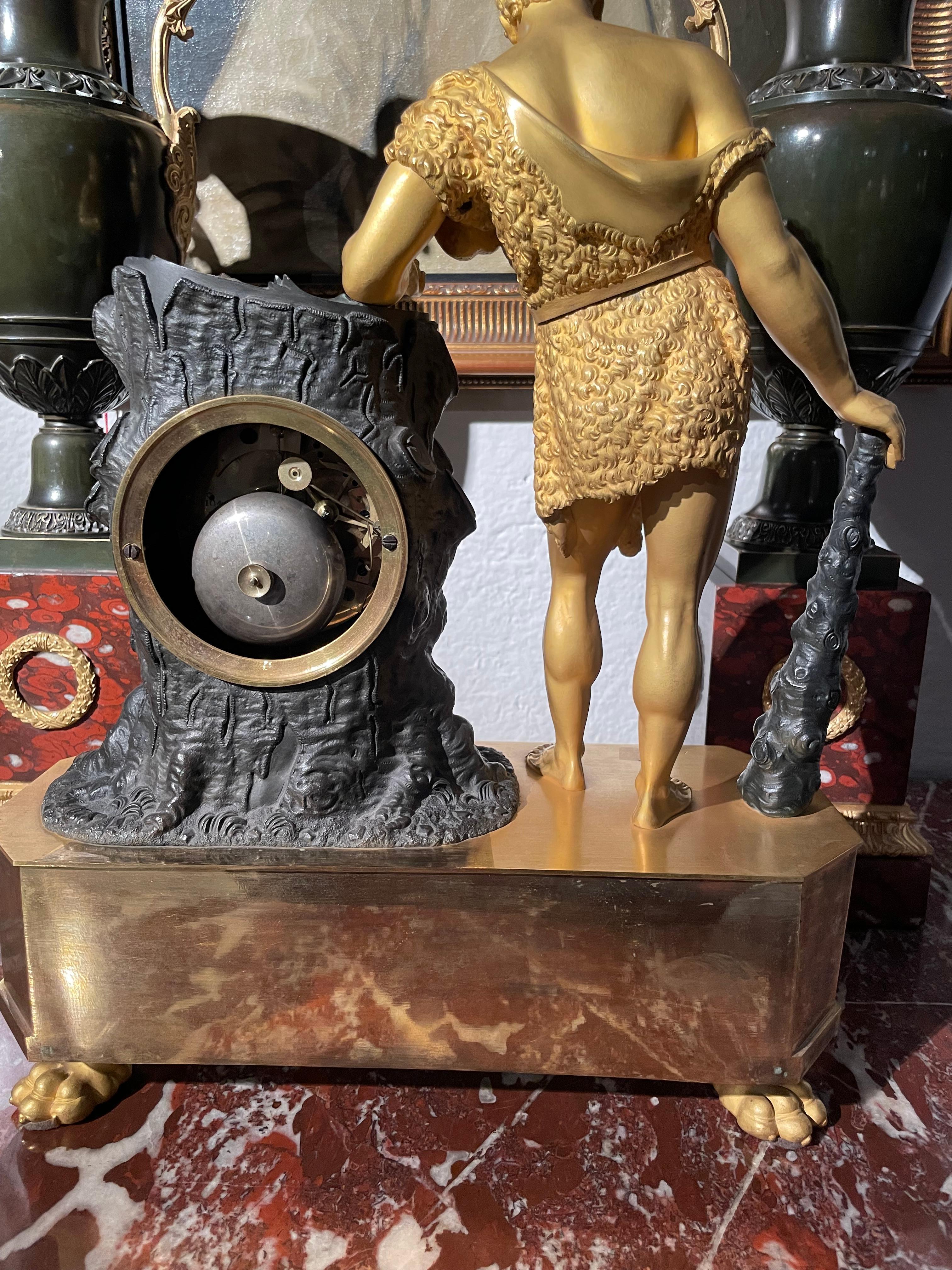 Represents Hercules leaning on a tree trunk with his mace and three apples in the left hand from the Garden of the Hesperides. 
Octagonal base on lion claw feet.
 Movement signed on the dial 