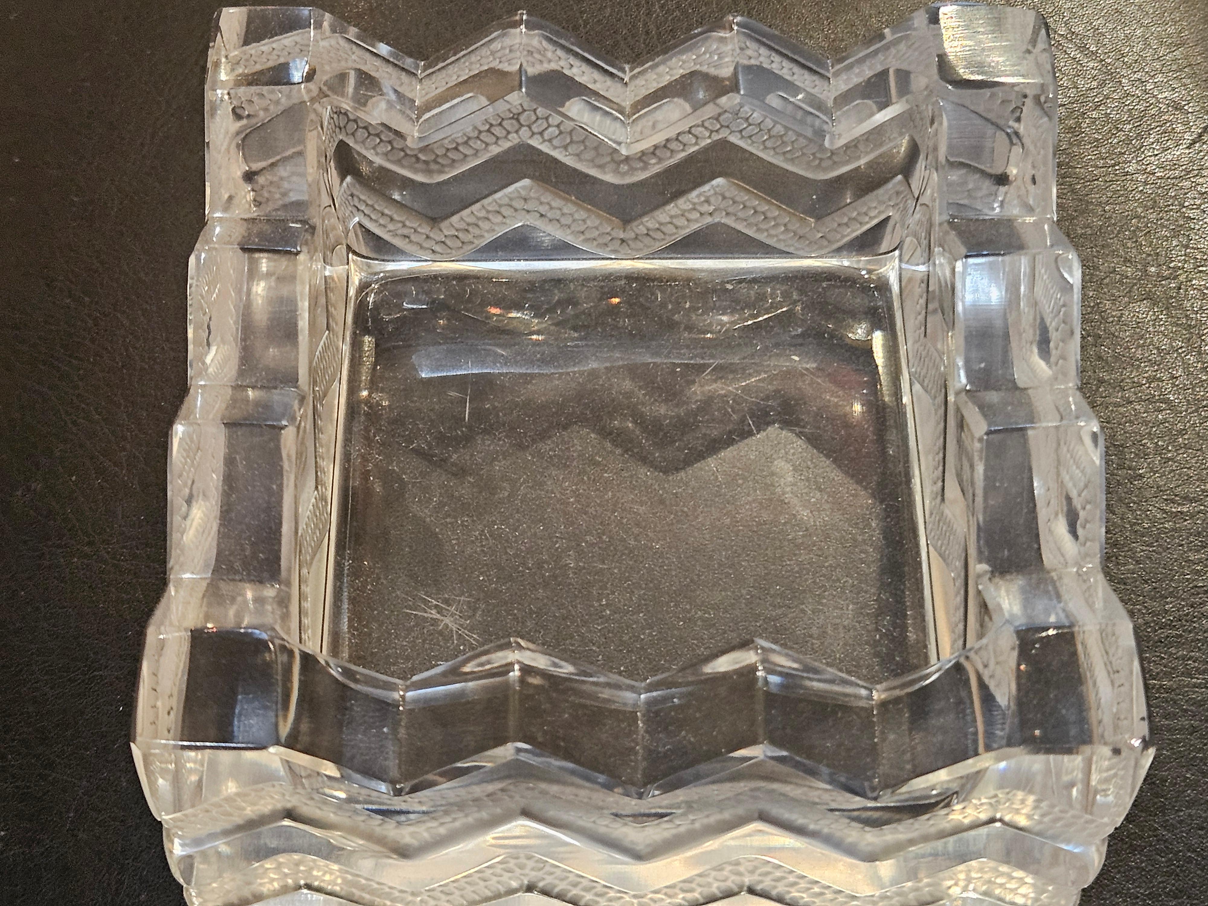  
Il seguente articolo che offriamo è una bellissima e rara ciotola portacenere a centrotavola di Lalique Zig Zag. Splendidamente cesellato e inciso con dettagli squisiti. Firmato con firma incisa di Lalique France sulla base. Estratto da una
