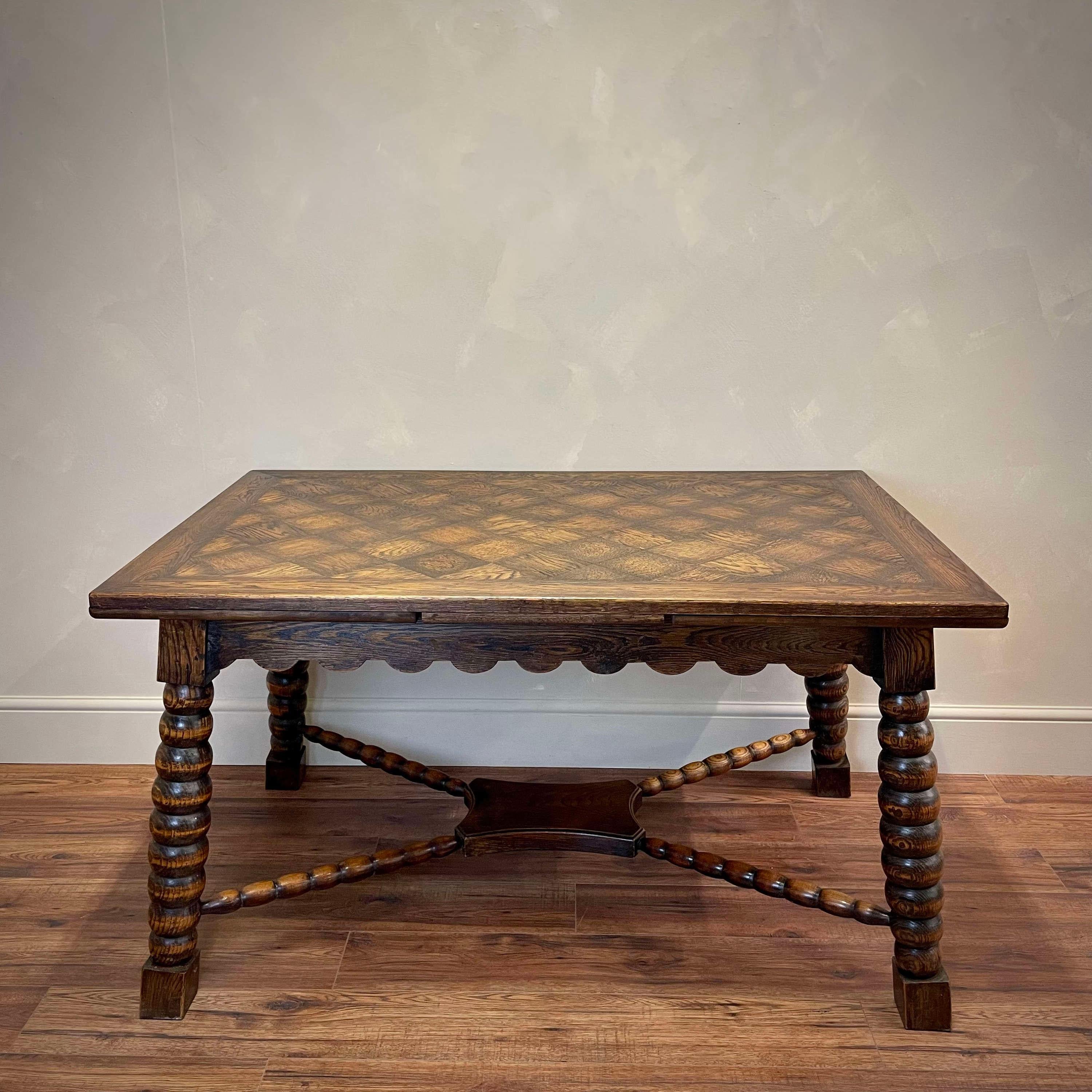 Beautiful carved wood table by Charles Dudouyt, made in France, 1940's. Rectangular top with beautiful oak wood veneer parquet design. Decoratively turned x-stretcher, scalloped apron and strong, oversized bobbin turned legs. Original dark wood