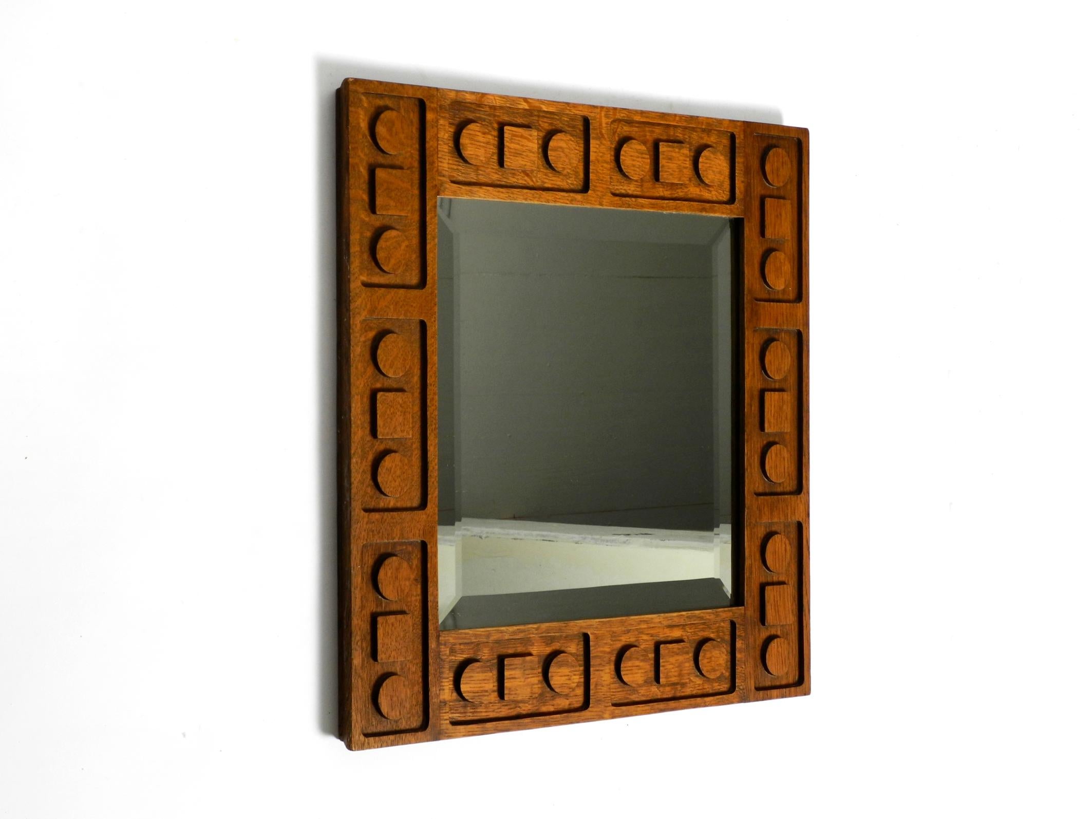 Beautiful artful 1930s wall mirror made of dark oak wood.
Great Art Deco design from the 30s. Made in Germany.
Very elaborately manufactured with the graphic motifs on the frame.
Very good vintage condition with no damage and a fantastic light