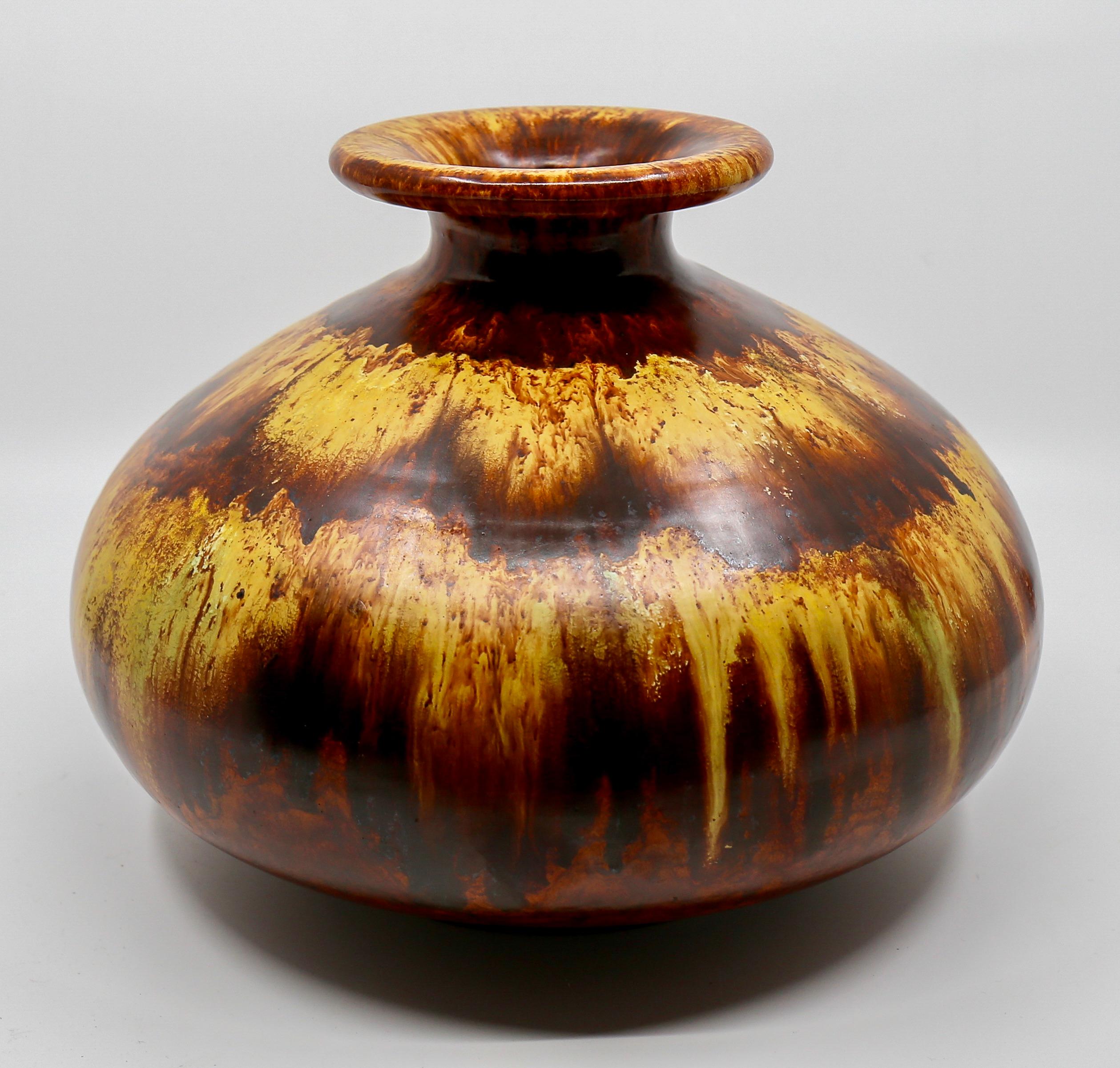 Beautiful spherical vase from the 1970s

Warm yellow and brown tones in a running glaze flow into a dark brown.
Good vintage condition, no chips. There are glaze defects on the bottom and on the inner edge of the opening.

Height; 19 cm, diameter;