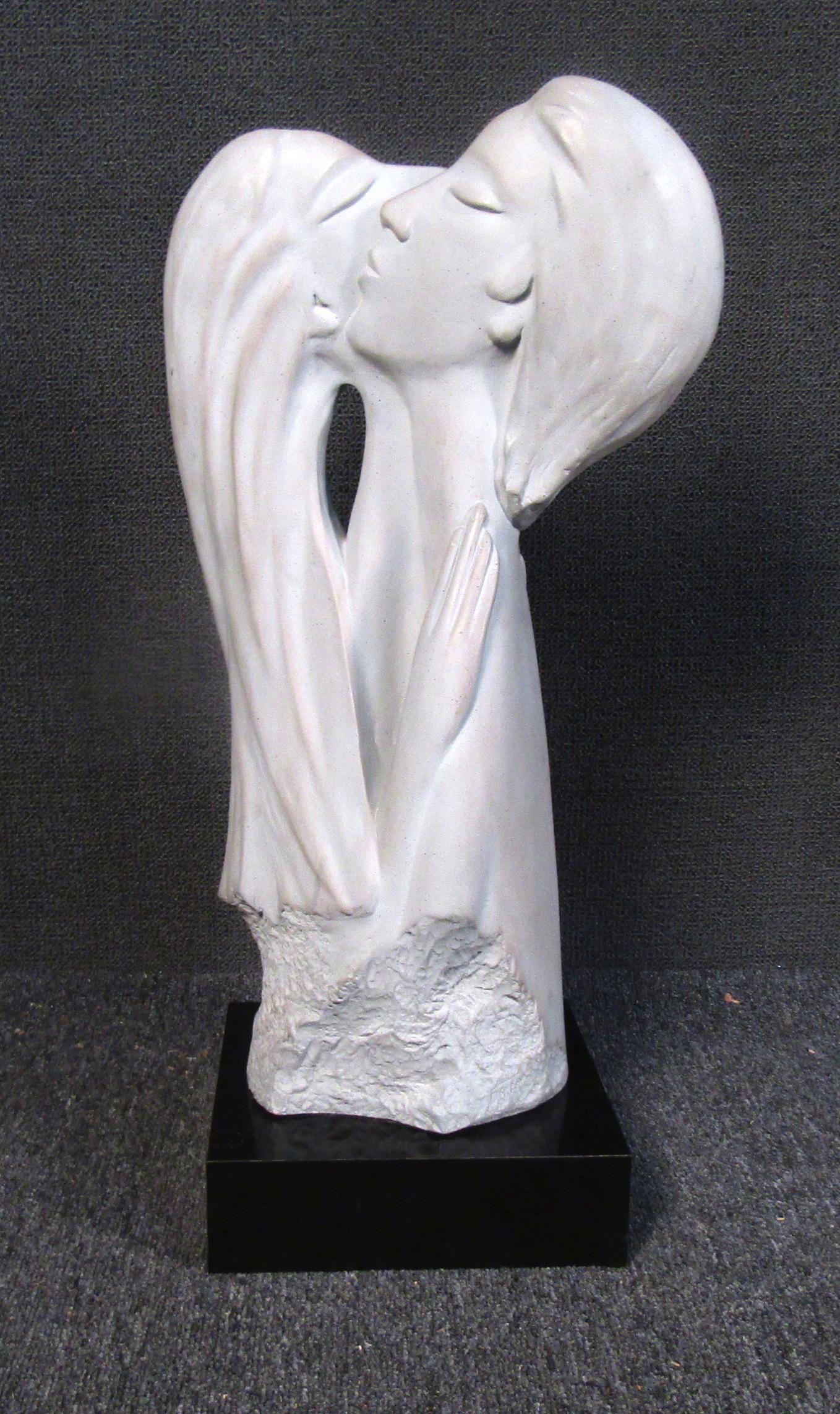 One of a kind elegant sculpture of two figures embracing. The sculpture is made of a white stone like material, on a polished black base. Signed and dated by Austin Productions circa 1985.

Please confirm item location (NY or NJ).