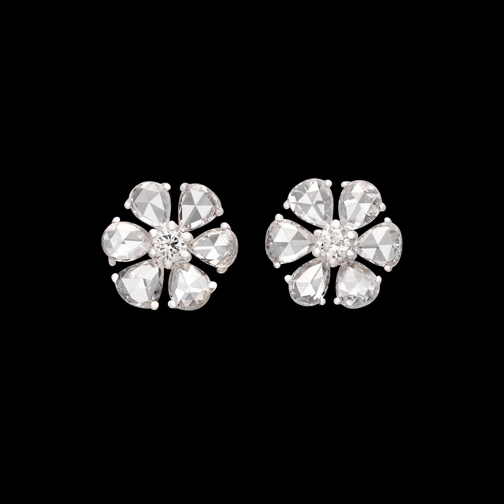 A stunning twist on a classic stud design! These 18 karat white gold stunners feature six expertly cut pear shaped diamond petals on each ear, with a round brilliant cut diamond making up the center of the flower design. The total diamond weight of