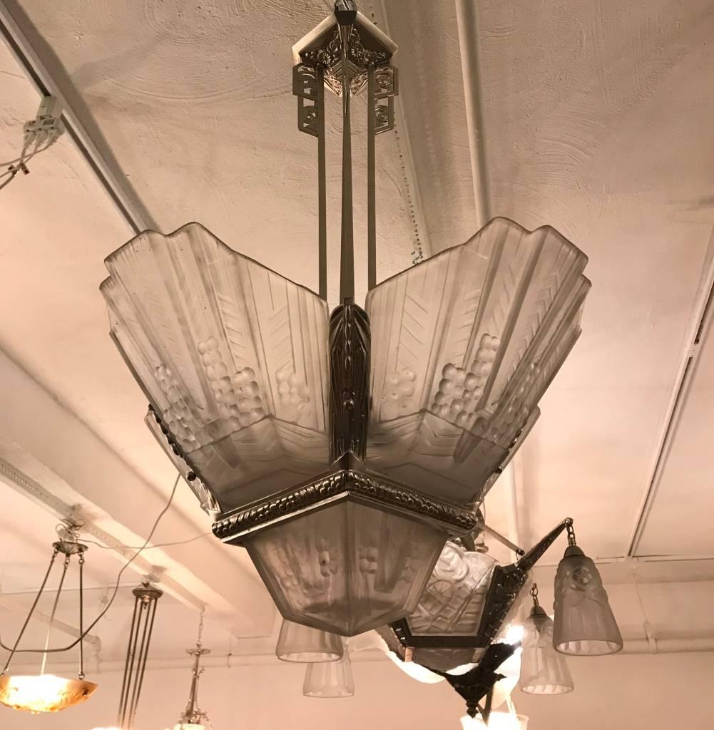 Stunning French Art Deco chandelier signed by E.J.G. having four clear frosted glass panels with center shade having intricate geometric motif. With matching polished nickel frame with beautiful geometric deco details. Has been rewired for American