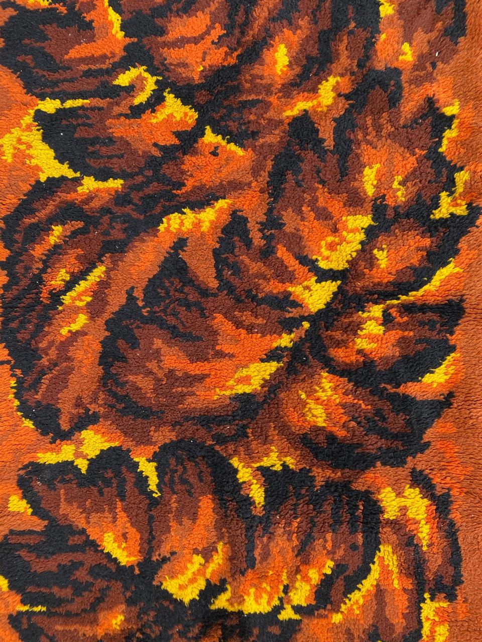 Magnifique tapis Art déco français avec un superbe design décoratif dans des tons chauds et terreux de brun, orange, jaune et noir. Cette pièce exquise est entièrement nouée à la main avec du velours de laine sur une base de coton, évoquant les