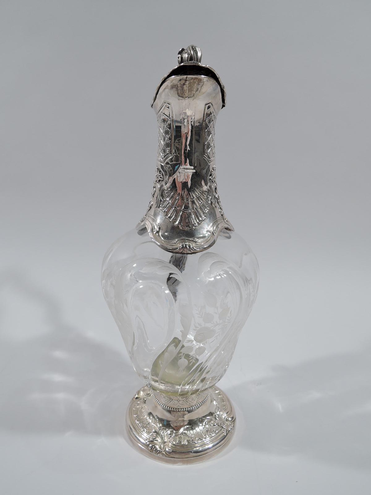 Beautiful turn-of-the-century Belle Époque Rococo silver and crystal decanter. Ovoid crystal body with alternating twisted flutes and lobes, and acid-etched blossoming flower branches. Neck has shaped base with leaves, shells, and flowers, as well