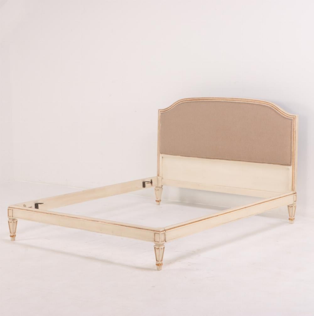 Beautiful French Directoire style painted and giltwood queen size bed, C 1940. This bed is bed a warm creamy white and has carved and gilt accents throughout. The fabric is newly upholstered and has never been used. This bed is just shy of a queen