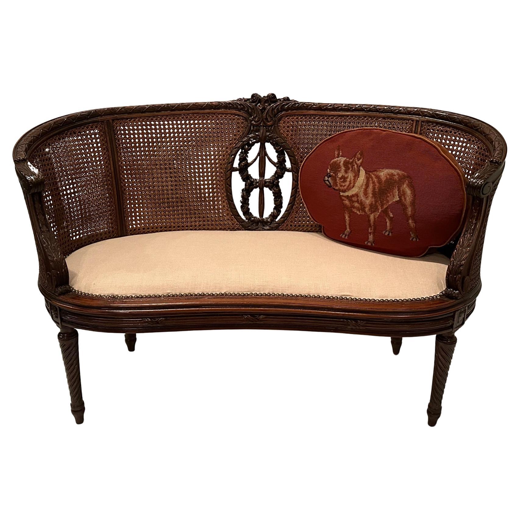 Beautiful hand carved mahogany loveseat having a central cartouche and original caning with upholstered off white seat.  The curved shape and detailed carvings make this a show stopper.  arm height 27
