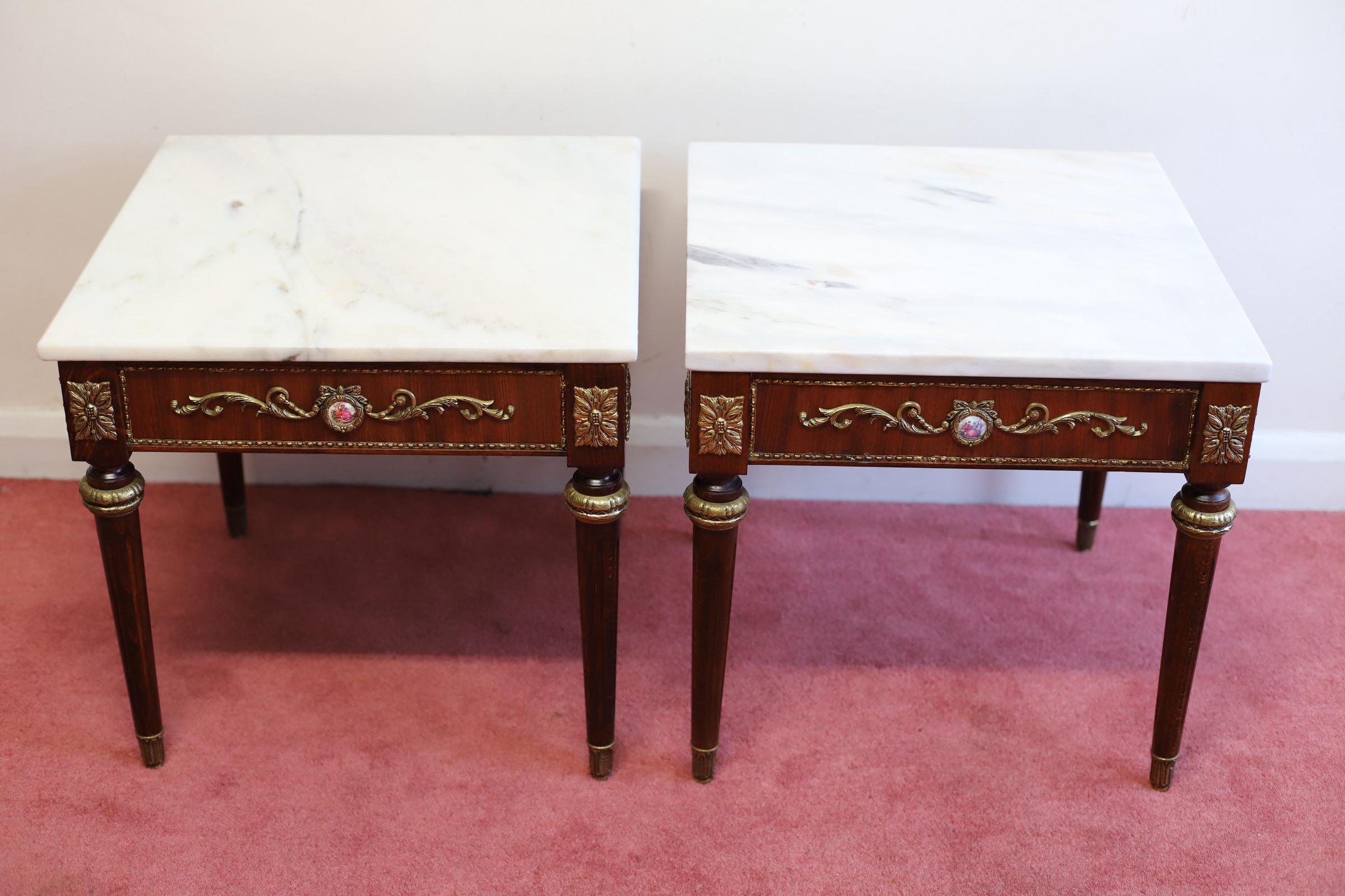 We delight to offer for sale this beautiful pair of marble-topped occasional tables in French Louis XVI taste, modern; the square tops above inset ceramic and gilt metal scroll decoration to the frieze; the corners with acanthus panel mounts, on