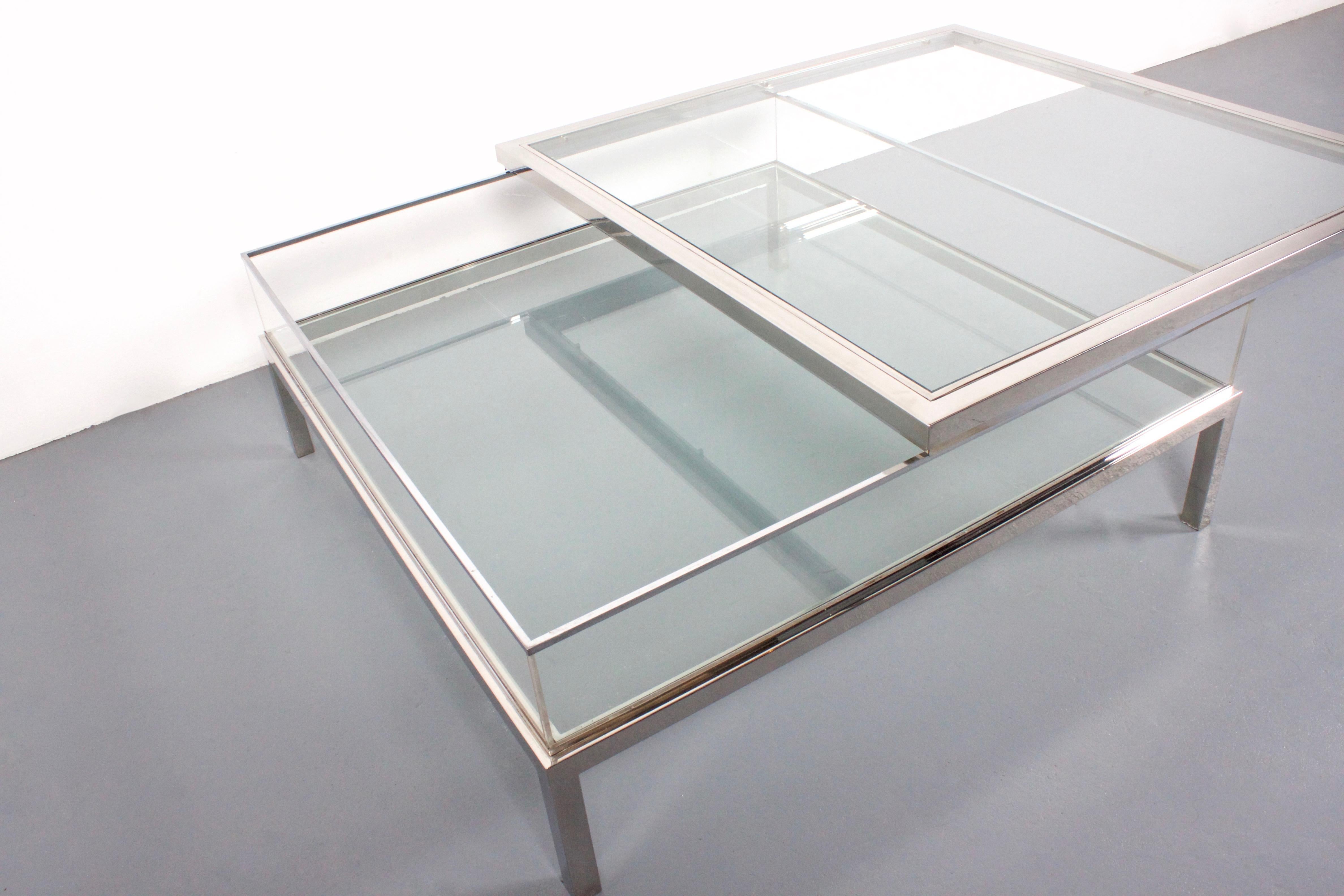 1970s coffee table by Maison Jansen in very good condition. 

Chrome with glass tops and Lucite walls. 

The top can slide open to reveal the inside compartment that can be used as a vitrine for books and magazines. 

This table is very heavy and