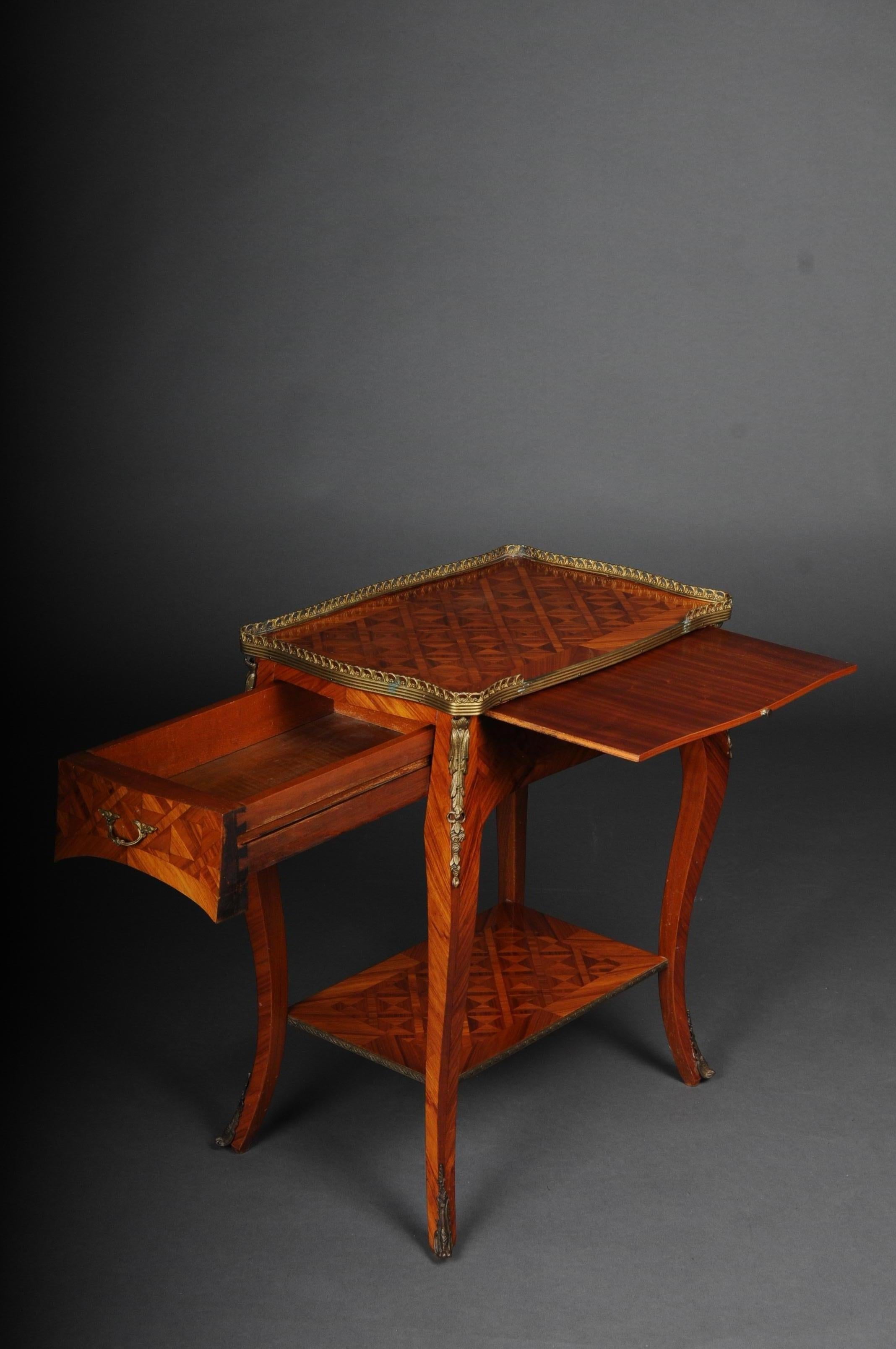 Beautiful French side table Louis XV, 20th century

Solid wood with tulip veneer. Single-compartment body with pull-out plate and between the shelf.
Curved legs with brass gallery. Veneer inlays on all sides.