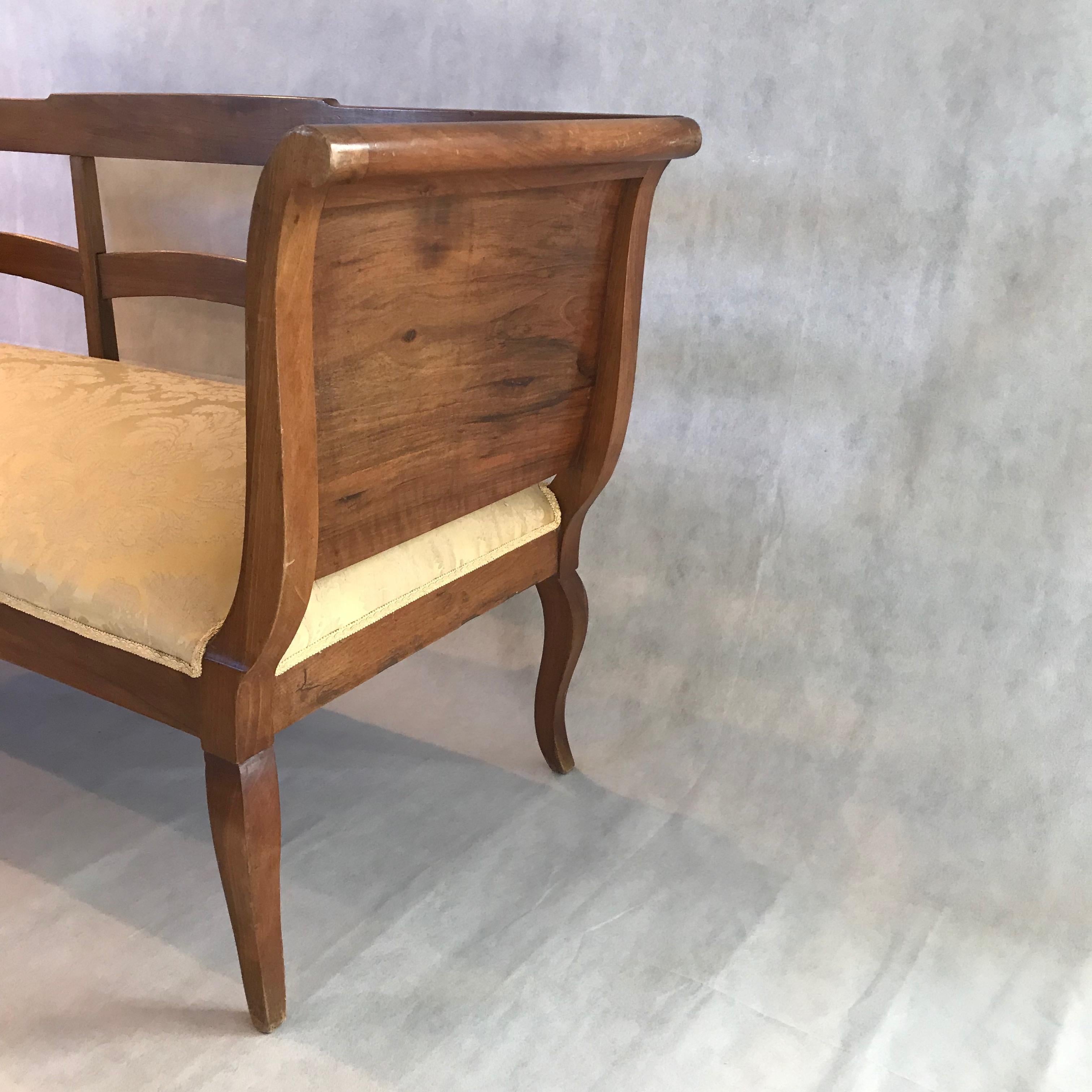 A fine walnut sleigh style settee or sofa having lovely curves, cabrioile legs, and elegant satiny golden jacard uphostery.