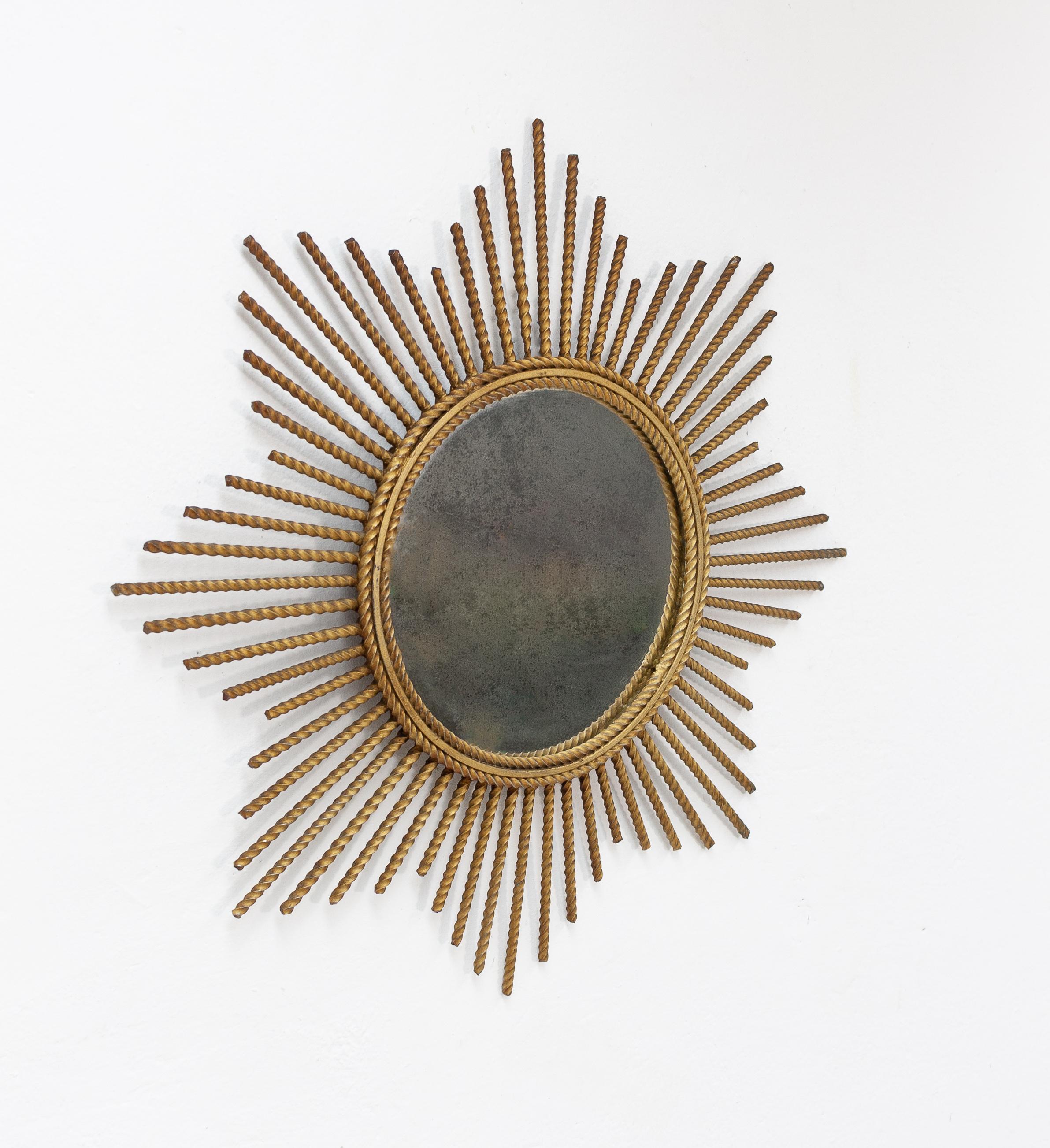 Beautiful gild metal sunburst mirror. In a Hollywood Regency style. Comes with the original gilding
a warm antique gold color. Handmade, Italy, 1960s with a lovely distressed mirror.

 