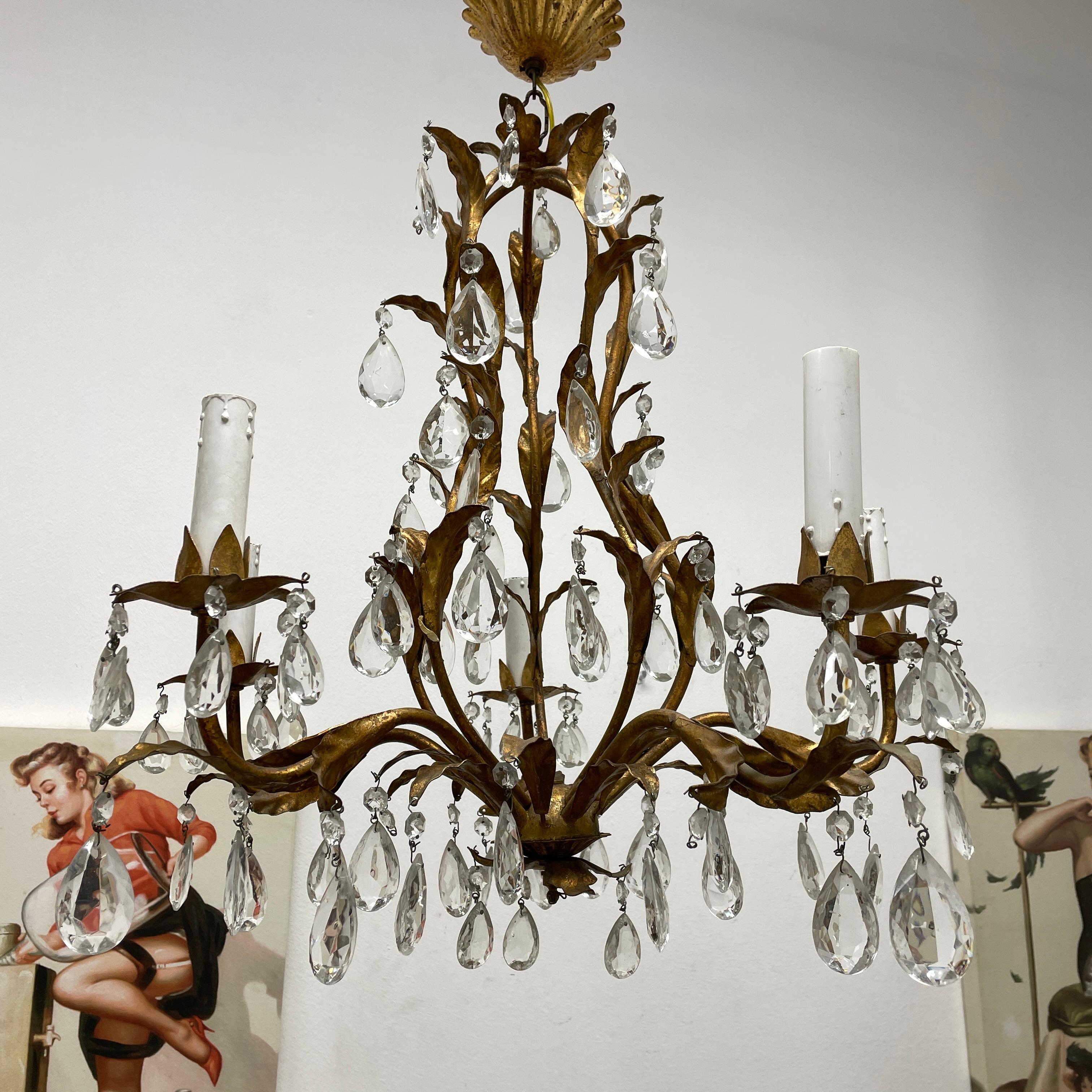 Add a touch of opulence to your home with this charming chandelier! Perfect gilt Metal and crystal glass to enhance any chic or eclectic home. We'd love to see it hanging in an entry hall or in a Living / Dinning room area. Built in the 1960s,
