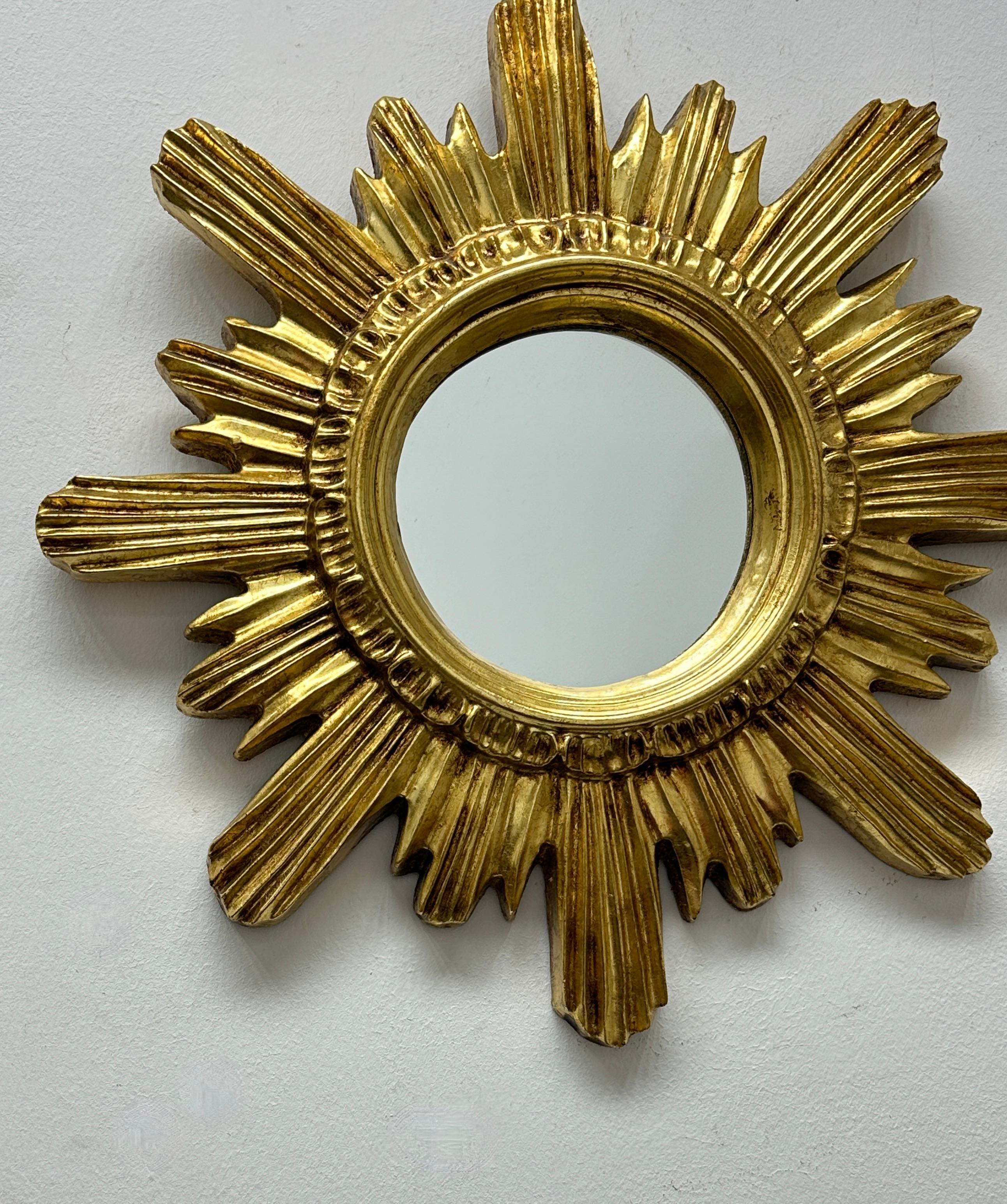 A gorgeous starburst mirror. Made of plastic or resin. No chips, no cracks, no repairs. It measures approximately 16.25