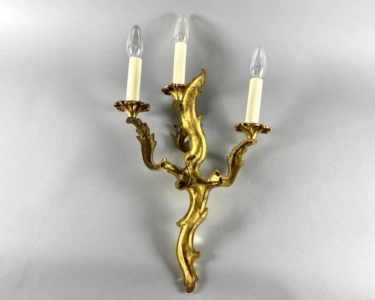 Beautiful Rococo style wall lamp with three sconces. Vintage.

 Support in gilded bronze and handcrafted by craftsmen.

 The decor consists of stylized acanthus scrolls intertwined with the Rococo style.

 This Unique wall sconce will easily