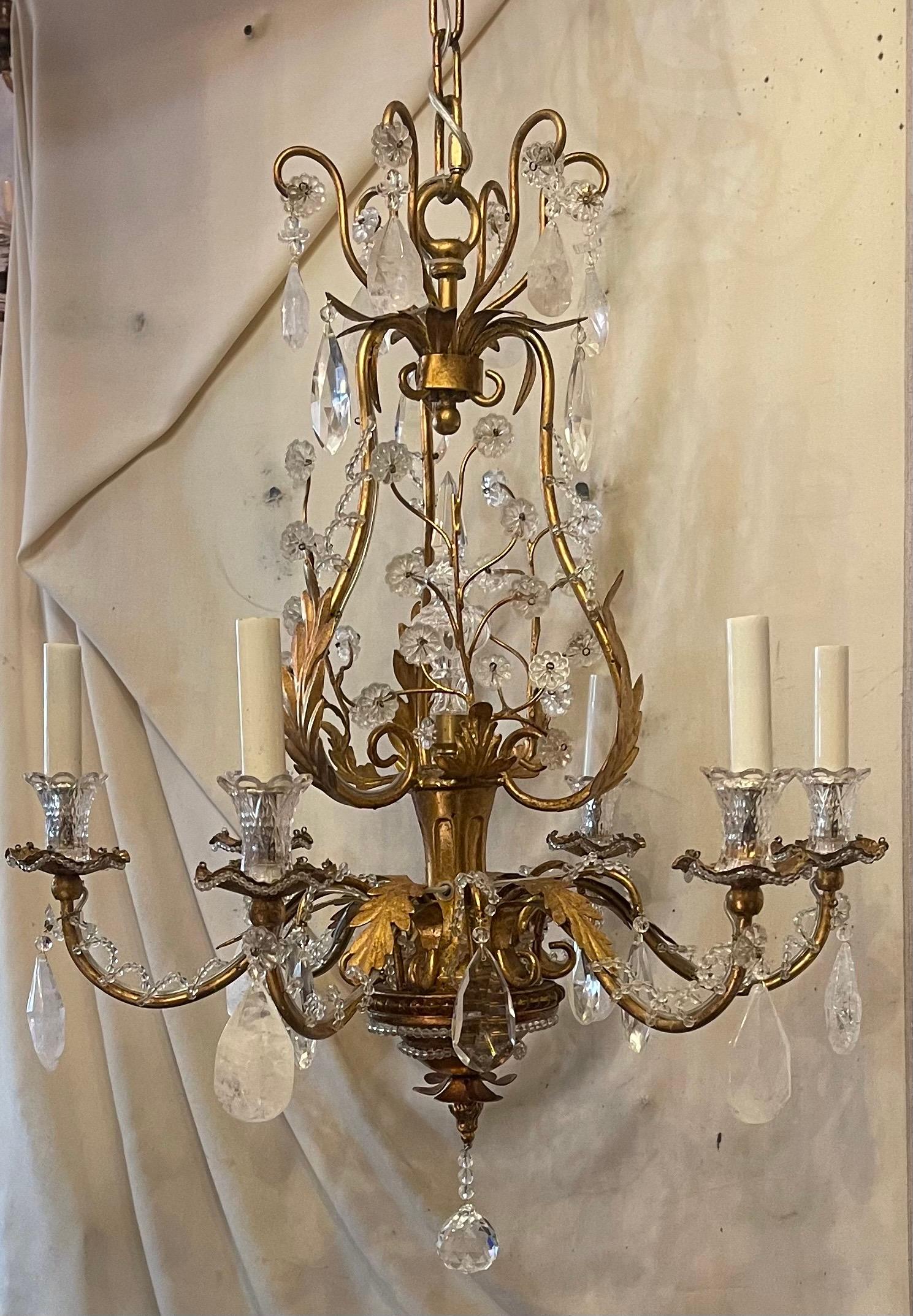 Magnifique lustre en forme de panier en or doré et feuilles de cristal de roche alternées à la manière de Vaughan, Baguès et Jansen. Ce lustre comporte 6 lampes candélabres et est livré prêt à être installé avec une chaîne et des accessoires de