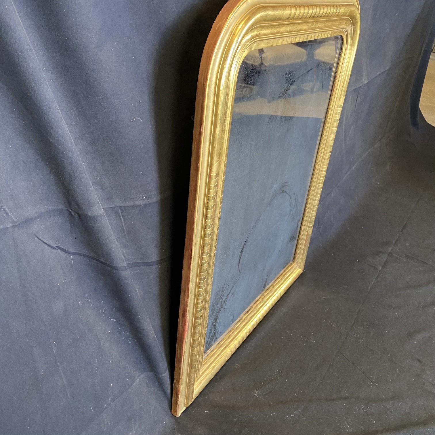 A handsome French gilt rectangular wall mirror featuring a raised, deeply detailed molded edge around the circumference and a lovely warm gold-leaf patina. Ready to hang. New glass. Bought in the South of France.  #5456
Dimensions: H 45.5” x W 37.5”