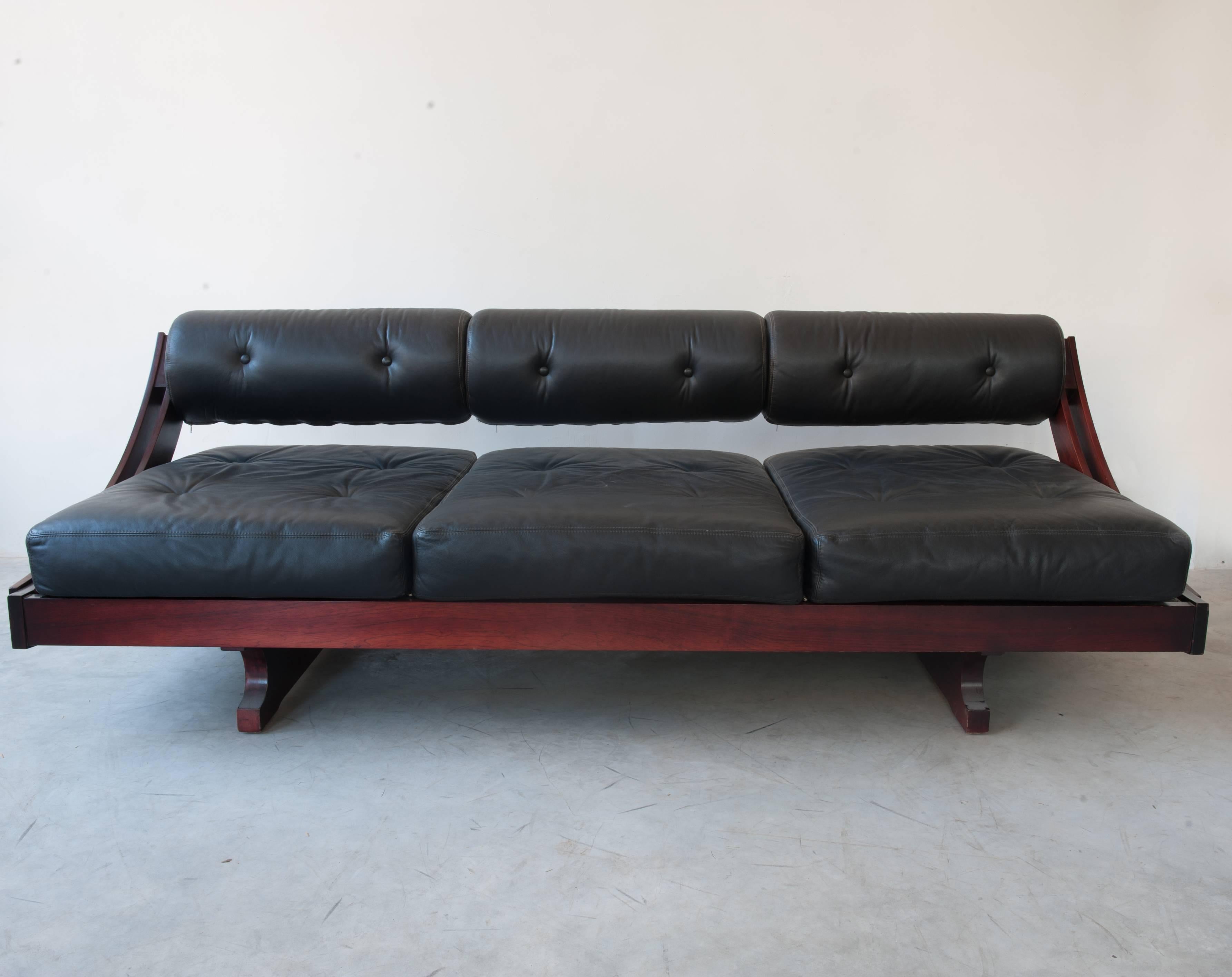 Very elegant and sculptural frame with a black original leather upholstery. 
The backrest can be adjusted in two positions to use as a sofa or daybed and is working properly. 
The soft original black leather cushions on the seat and backrest all