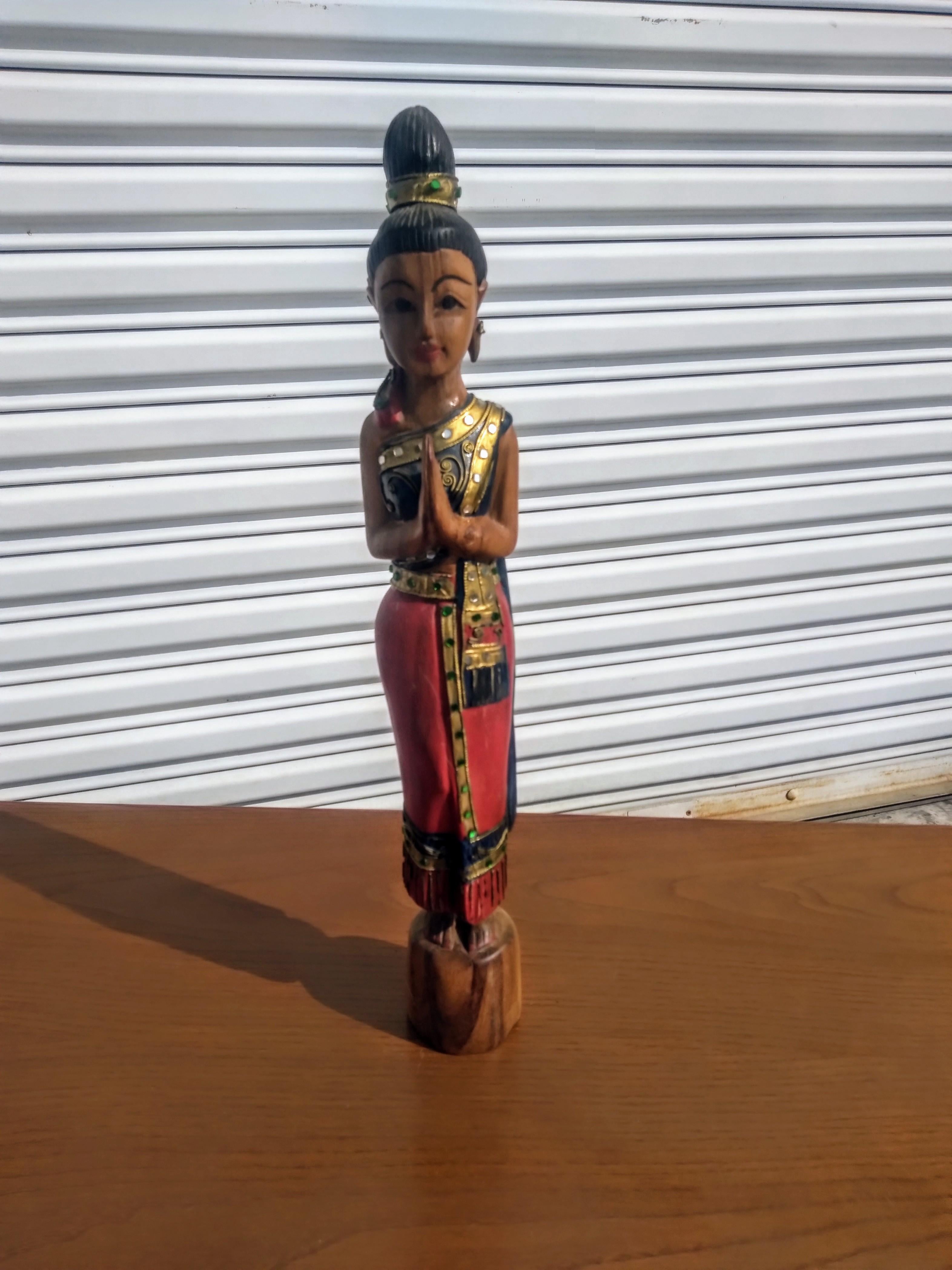 This beautiful sculpture is hand carved and painted. It depicts a beautiful Thai woman dress in adornment. It's beautifully painted and hand carved.