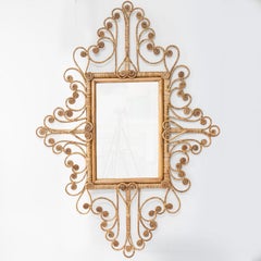 Magnifique miroir en rotin tressé à la main et orné de volutes